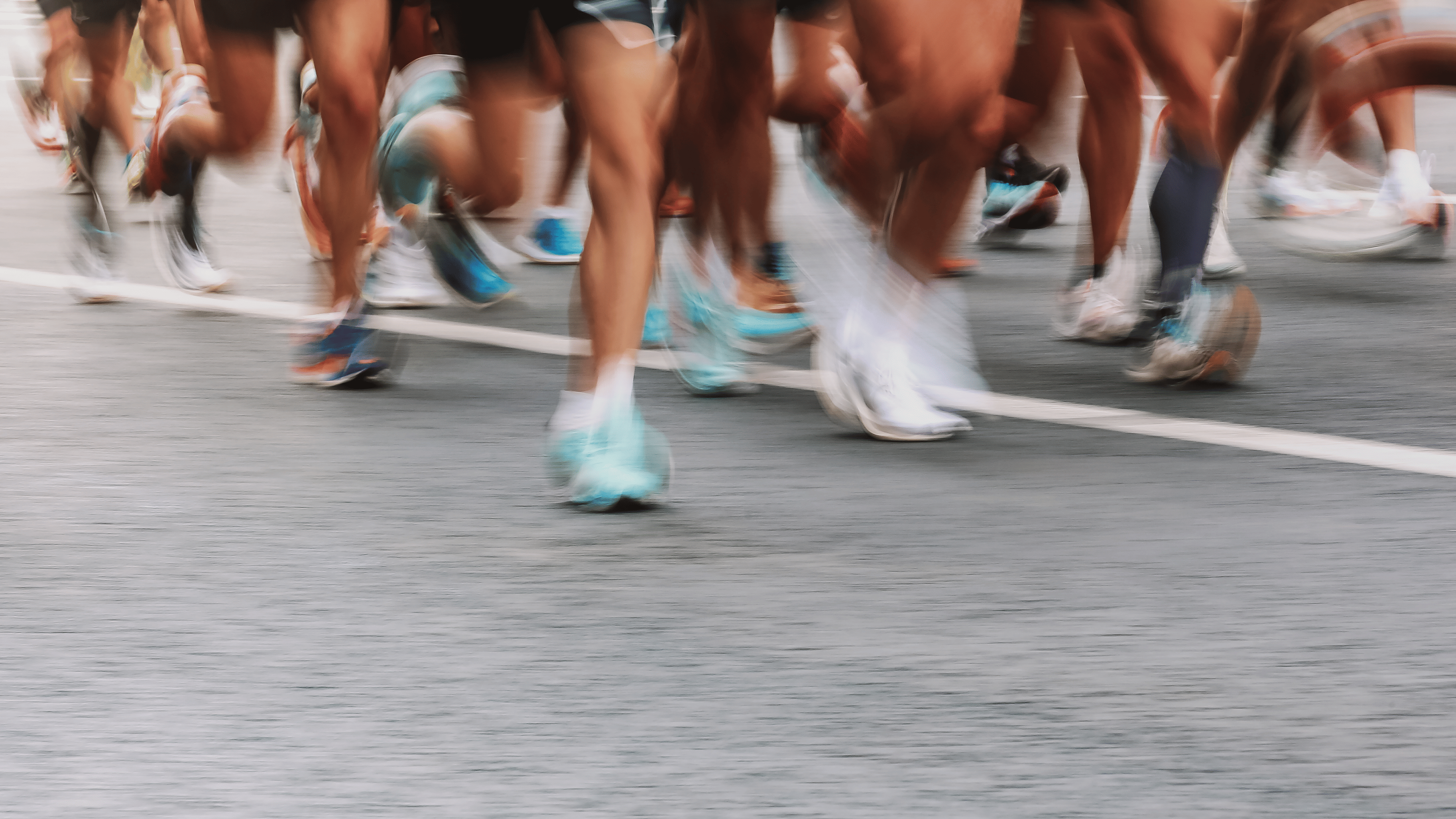 Blurry shot of people's feet while running a marathon.