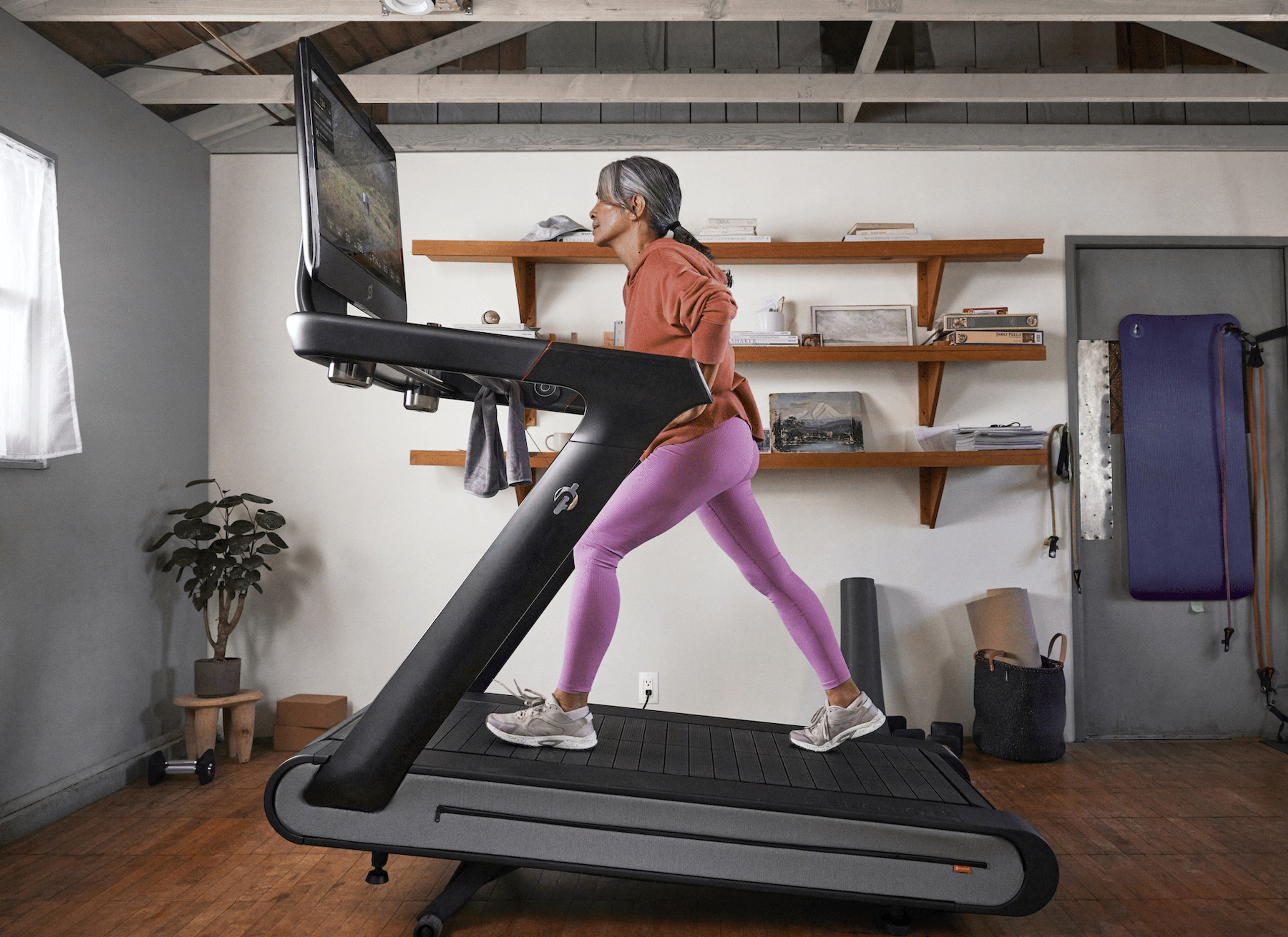 A woman hiking on her Peloton Tread+ at home.