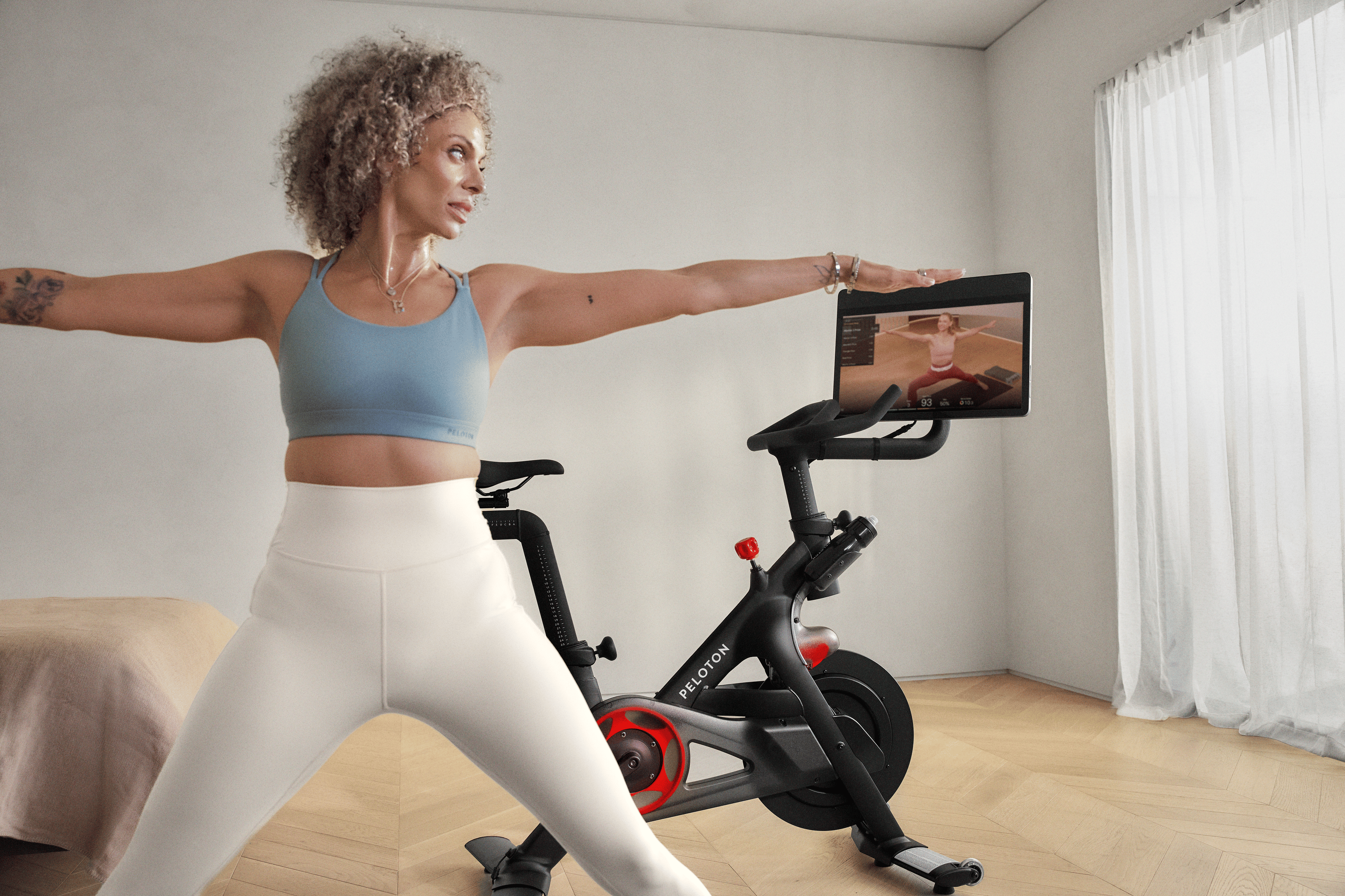 Woman doing a yoga cross training workout at home with her Peloton Bike.