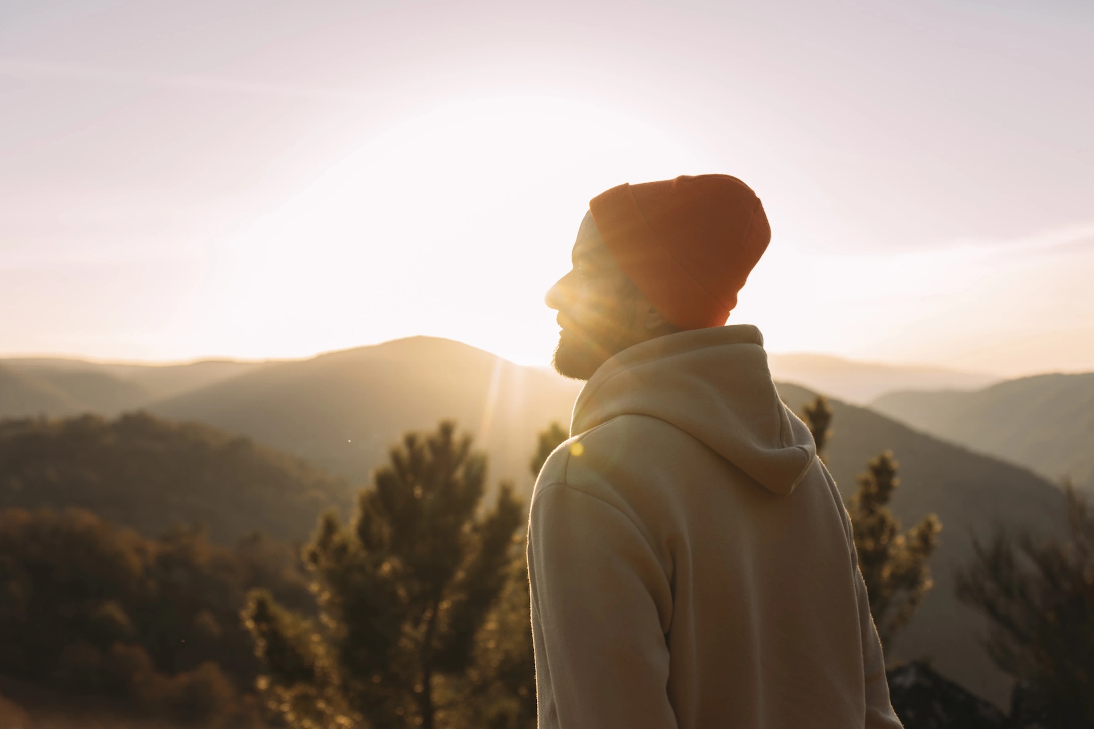 A man with inner strength. He is looking into the distance as he goes on a hike at sunrise.