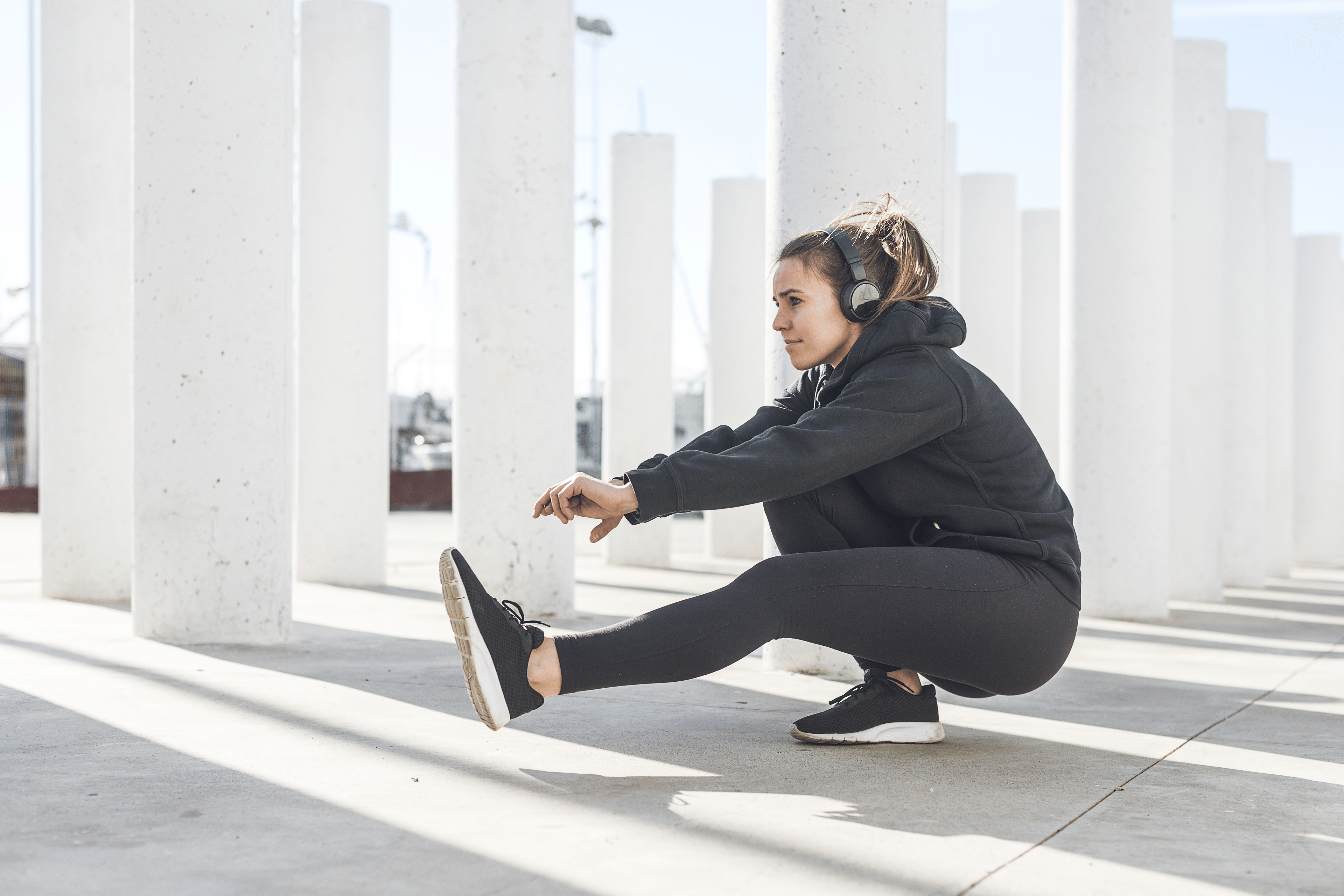 Woman practices a single leg or pistol squat 