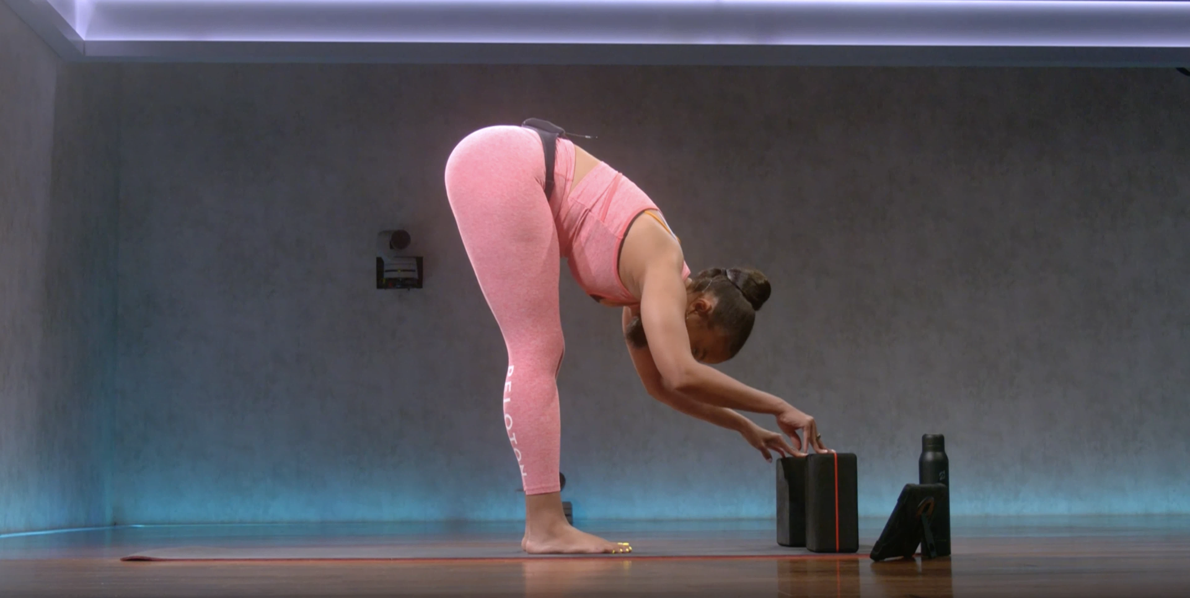 Chelsea Jackson Roberts demonstrates a forward fold yoga pose with yoga blocks 
