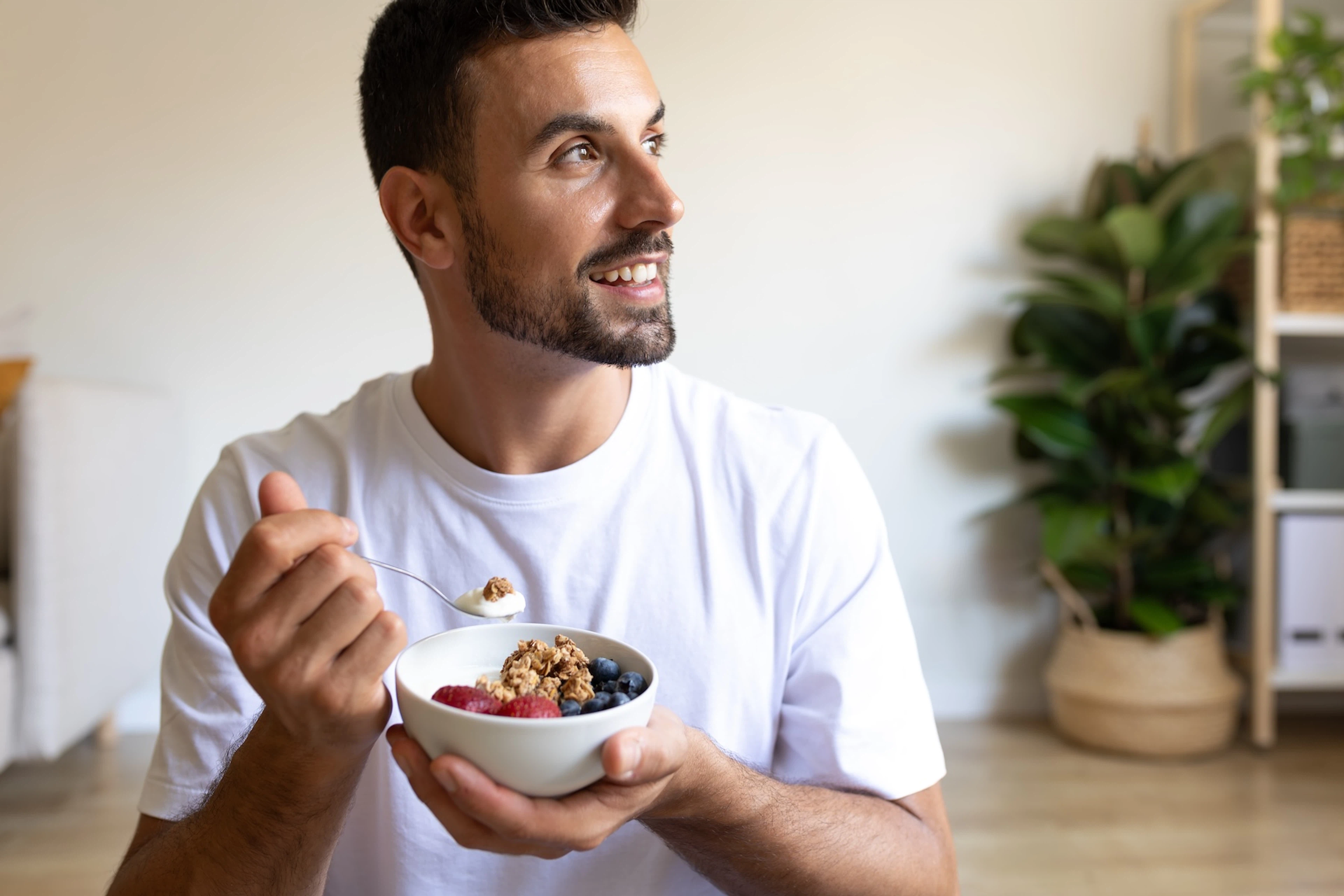 A man eating a yogurt parfait after a cardio workout.