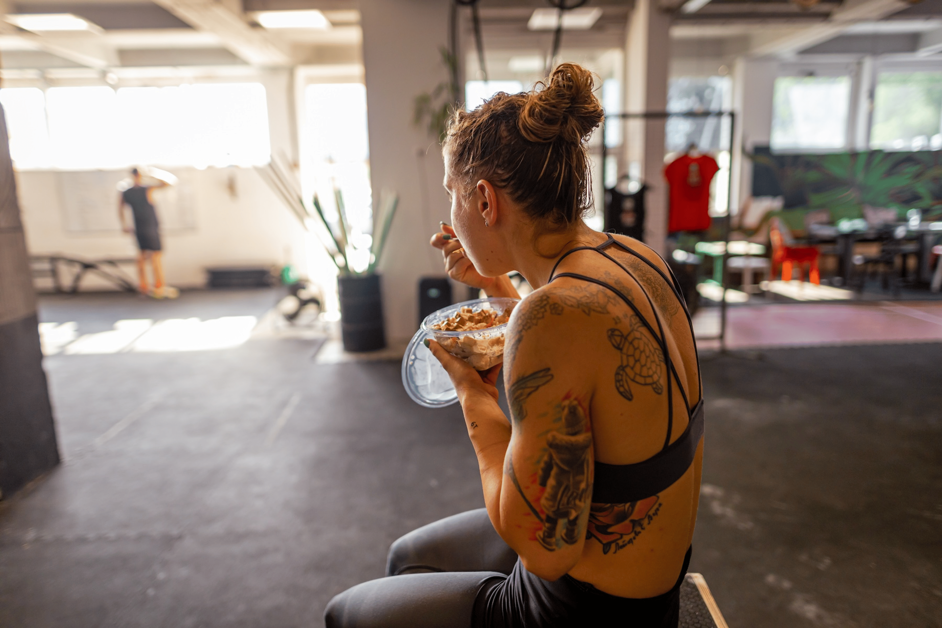 An athlete eating a meal in a gym after a workout.