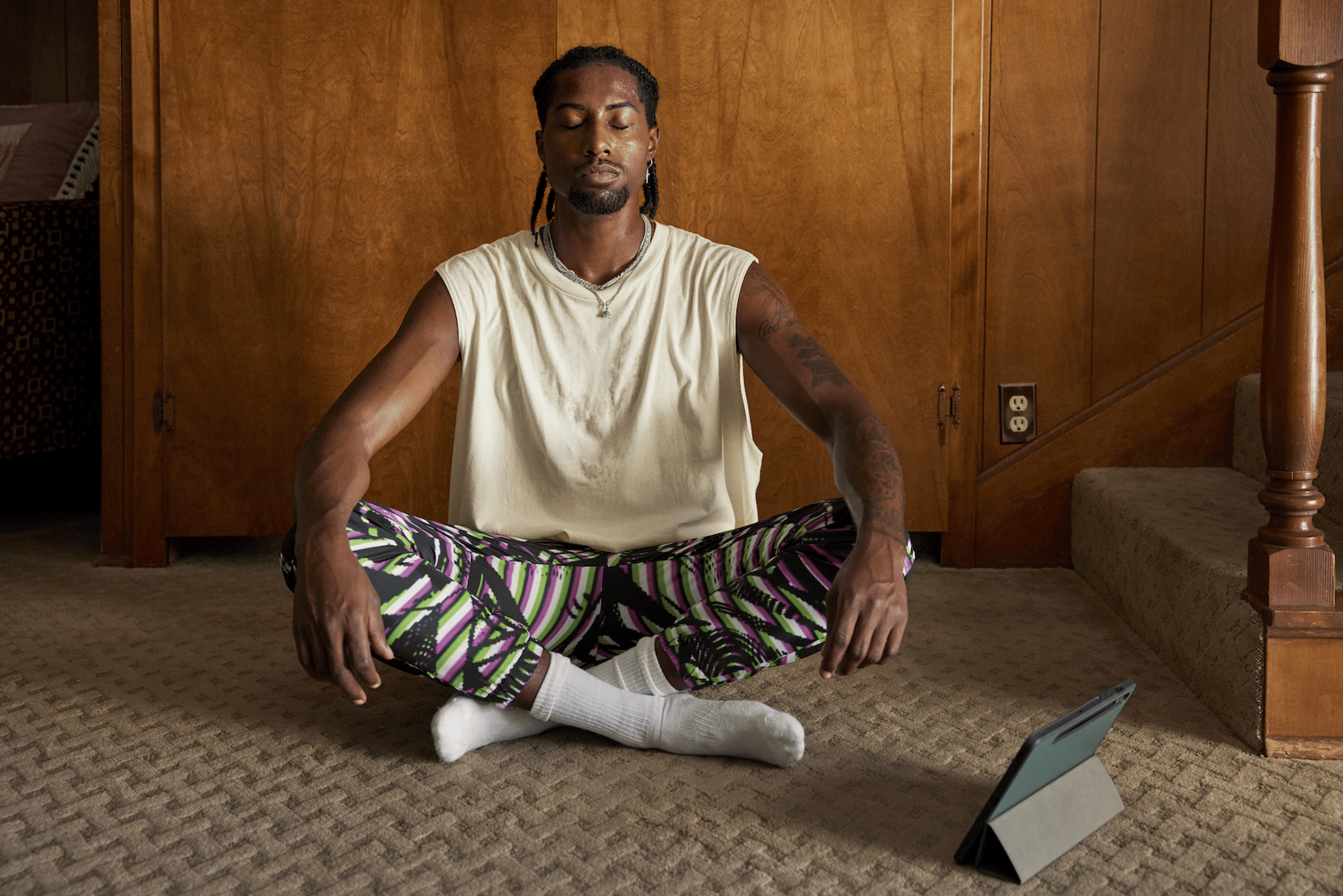 A young man sitting at home and practicing a meditation for anxiety.