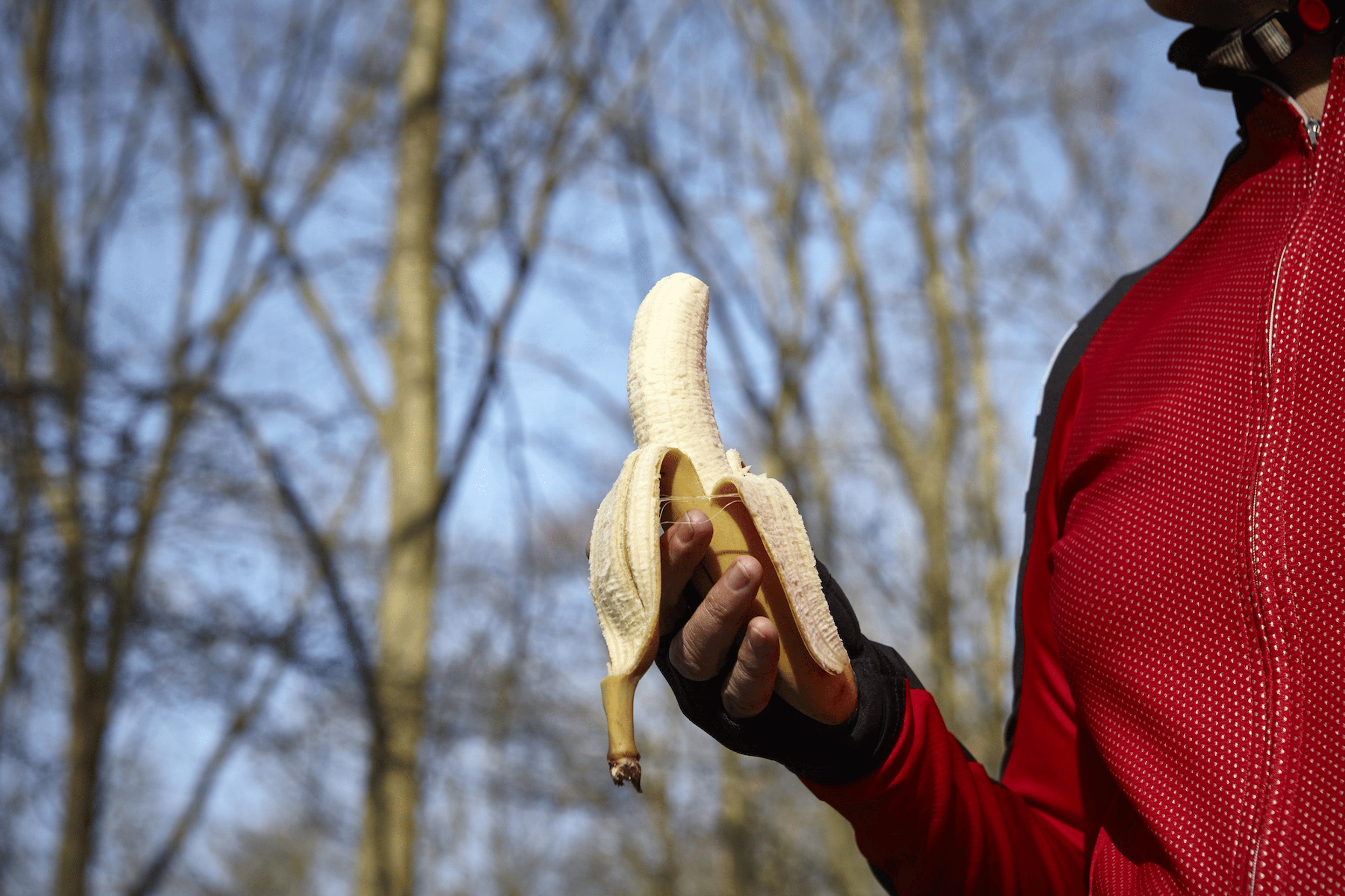 A close-up photo of an athlete holding a banana before a workout.