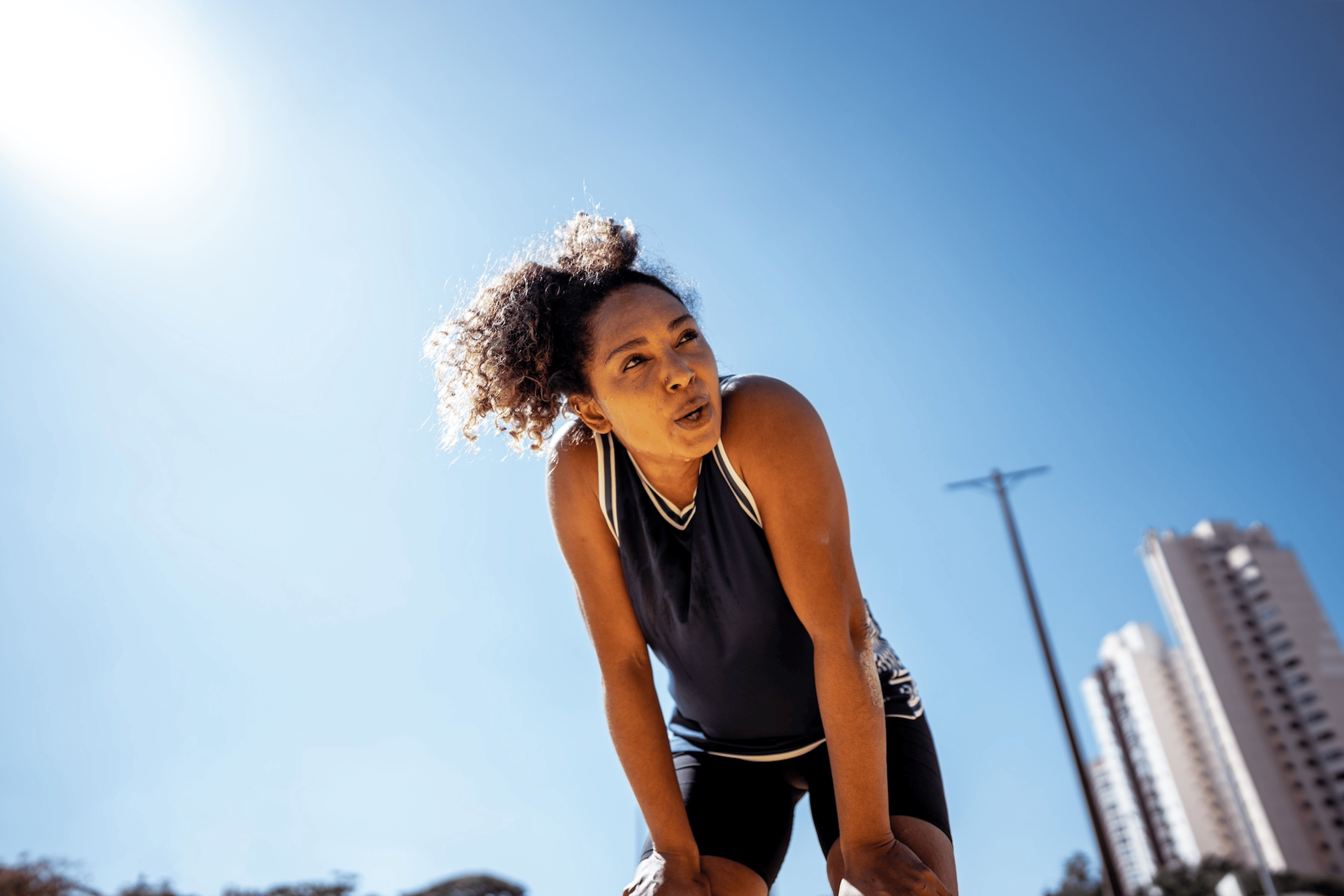 A woman catching her breath after a run outdoors. She is not hungry after her workout.