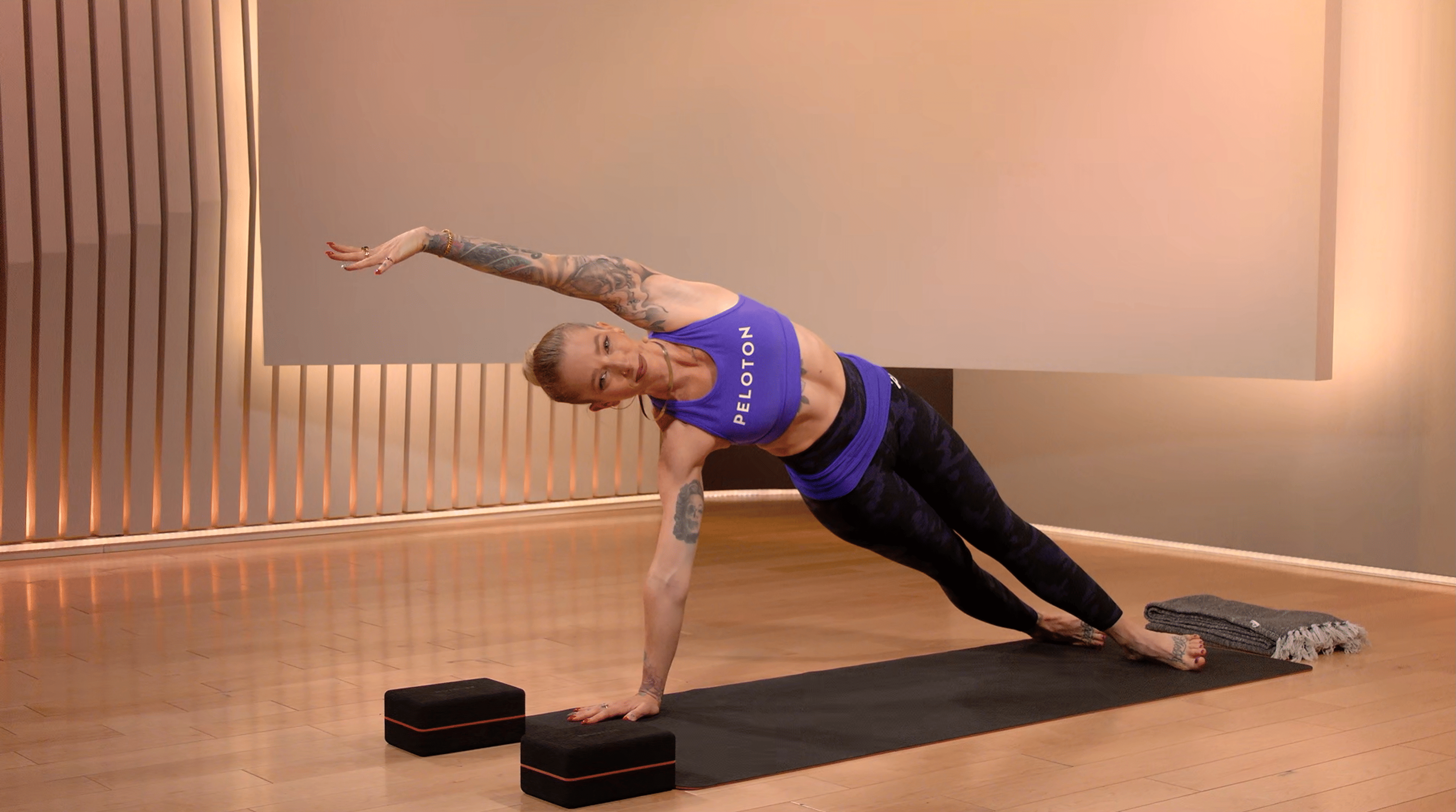 Peloton instructor Kirra Michel demonstrates a side plank during a yoga class on the Peloton App