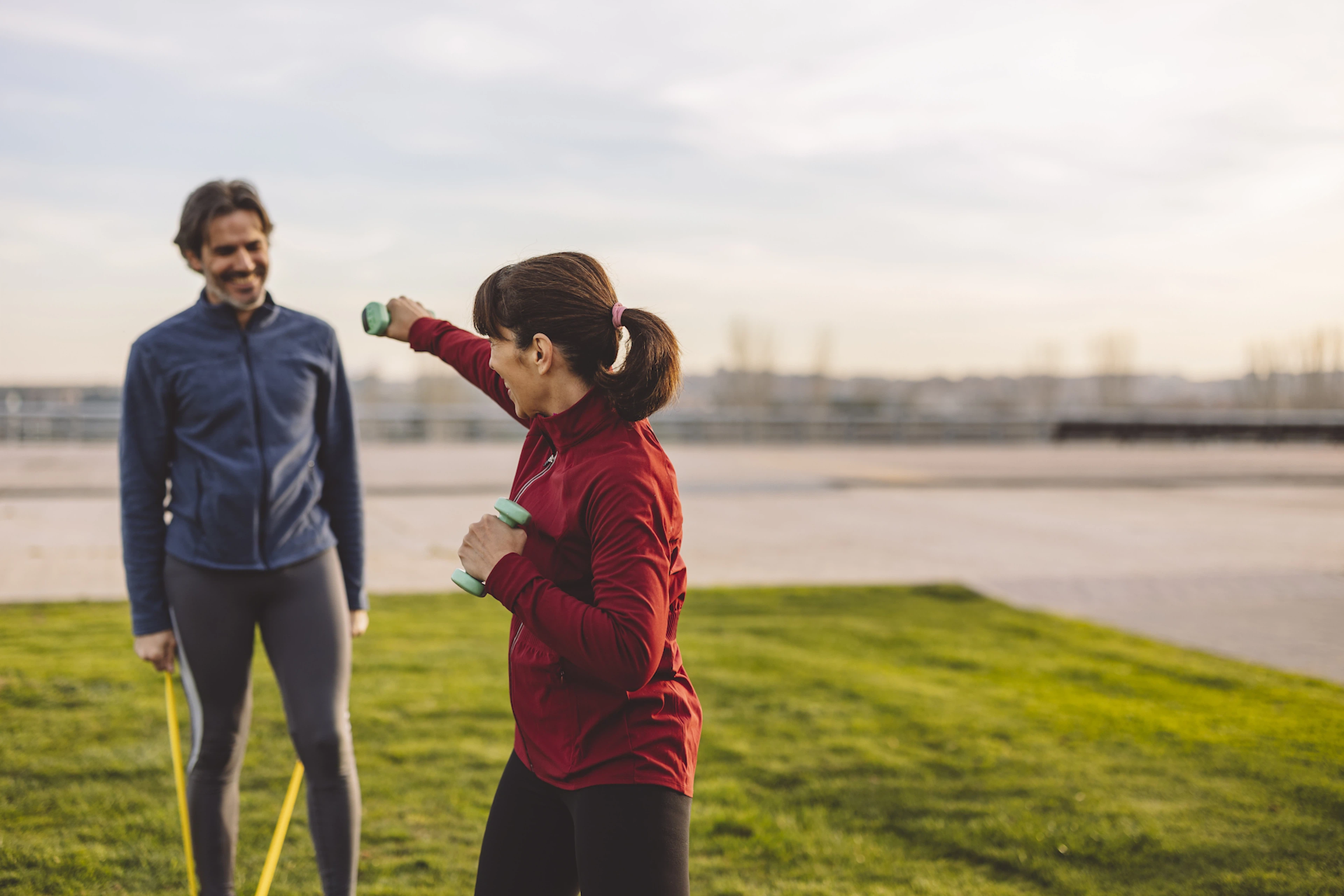 Woman boxes with dumbbells outside, what is shadowboxing