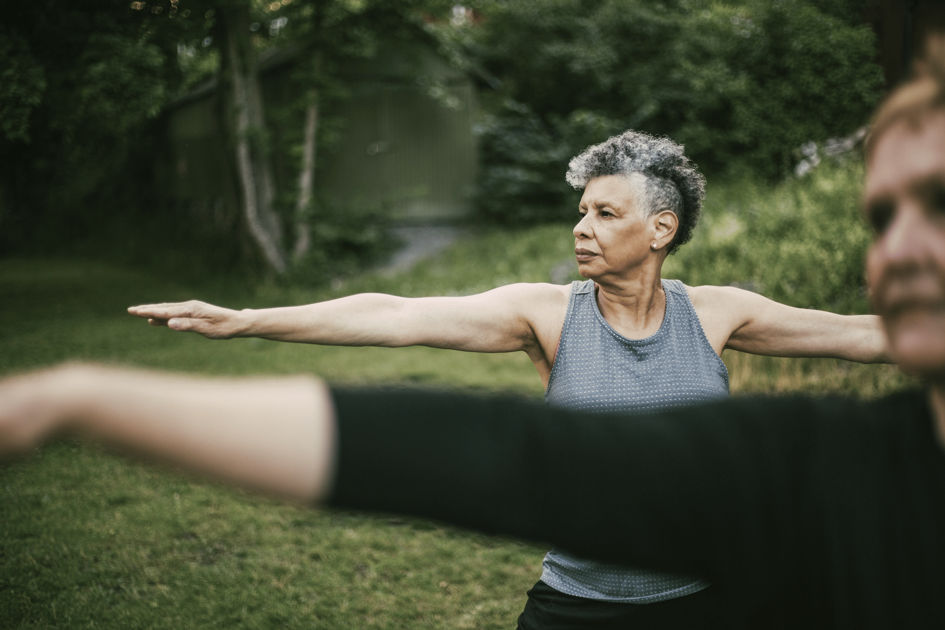 Woman shows how to engage your core while doing a yoga pose outside
