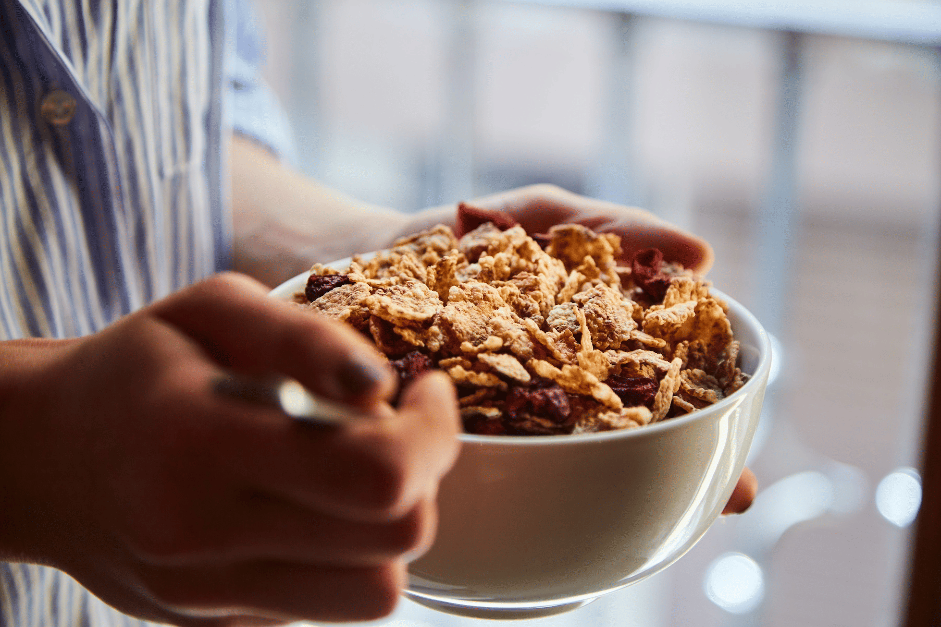A close-up photo of someone eating a bowel of cereal before running.