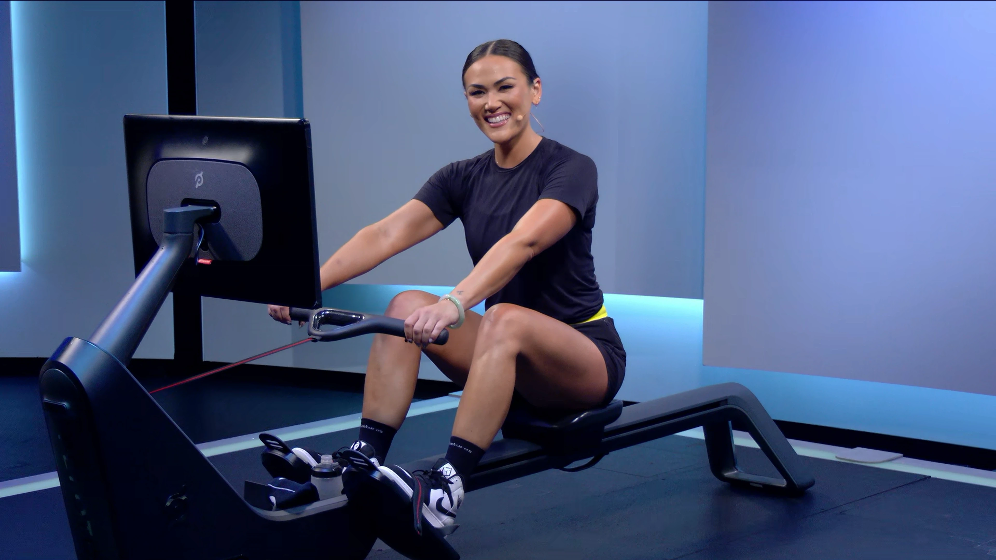 Katie Wang teaches a Peloton Row class, demonstrating proper rowing machine form