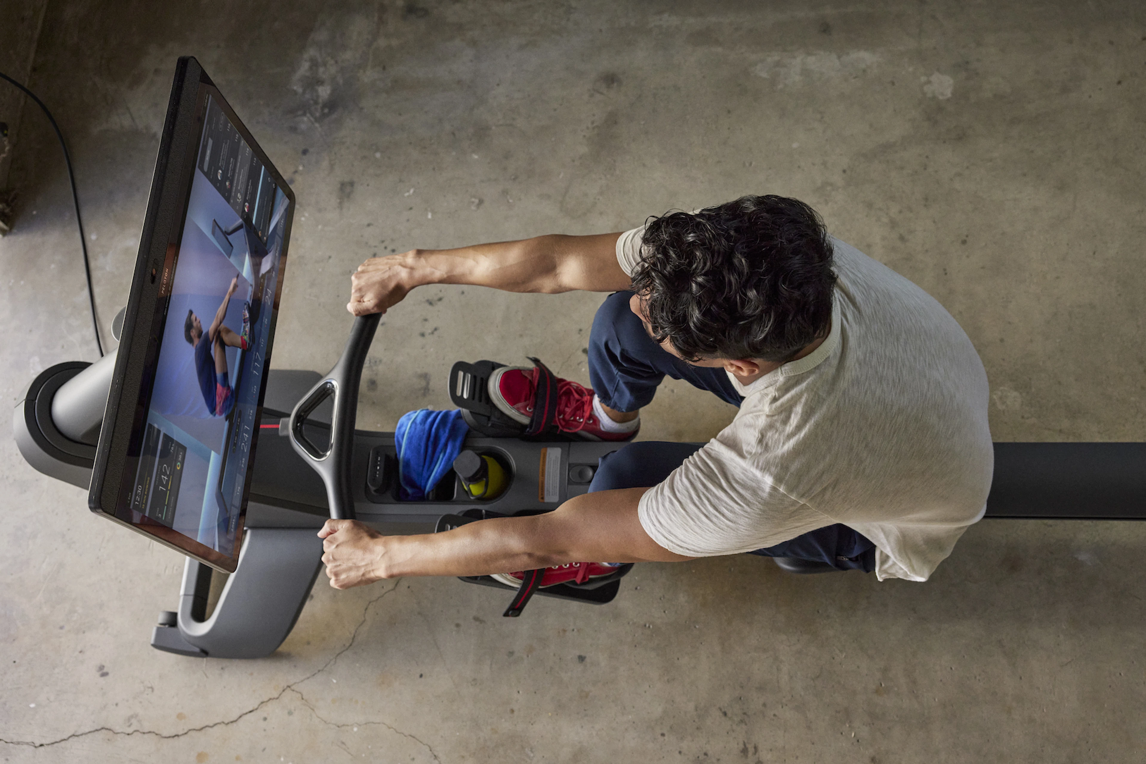 Man looks at his strokes per minute on a rowing machine