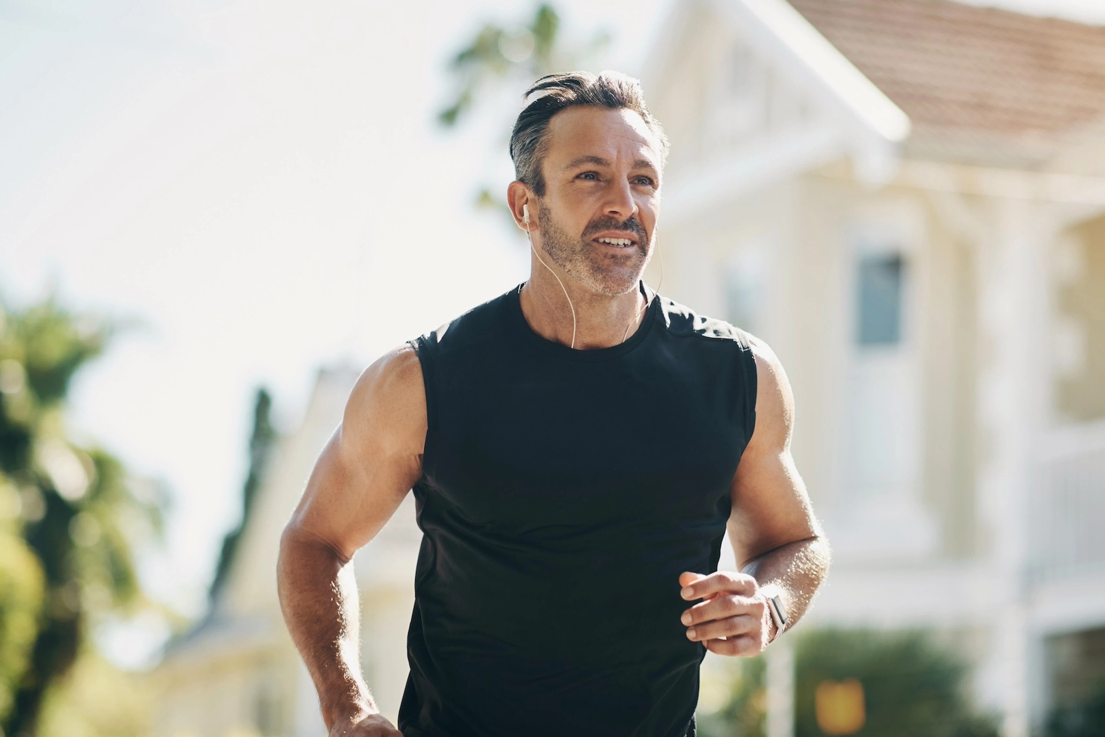 A man going for a run outdoors on a sunny day, using his rate of perceived exertion (RPE) to gauge his effort.