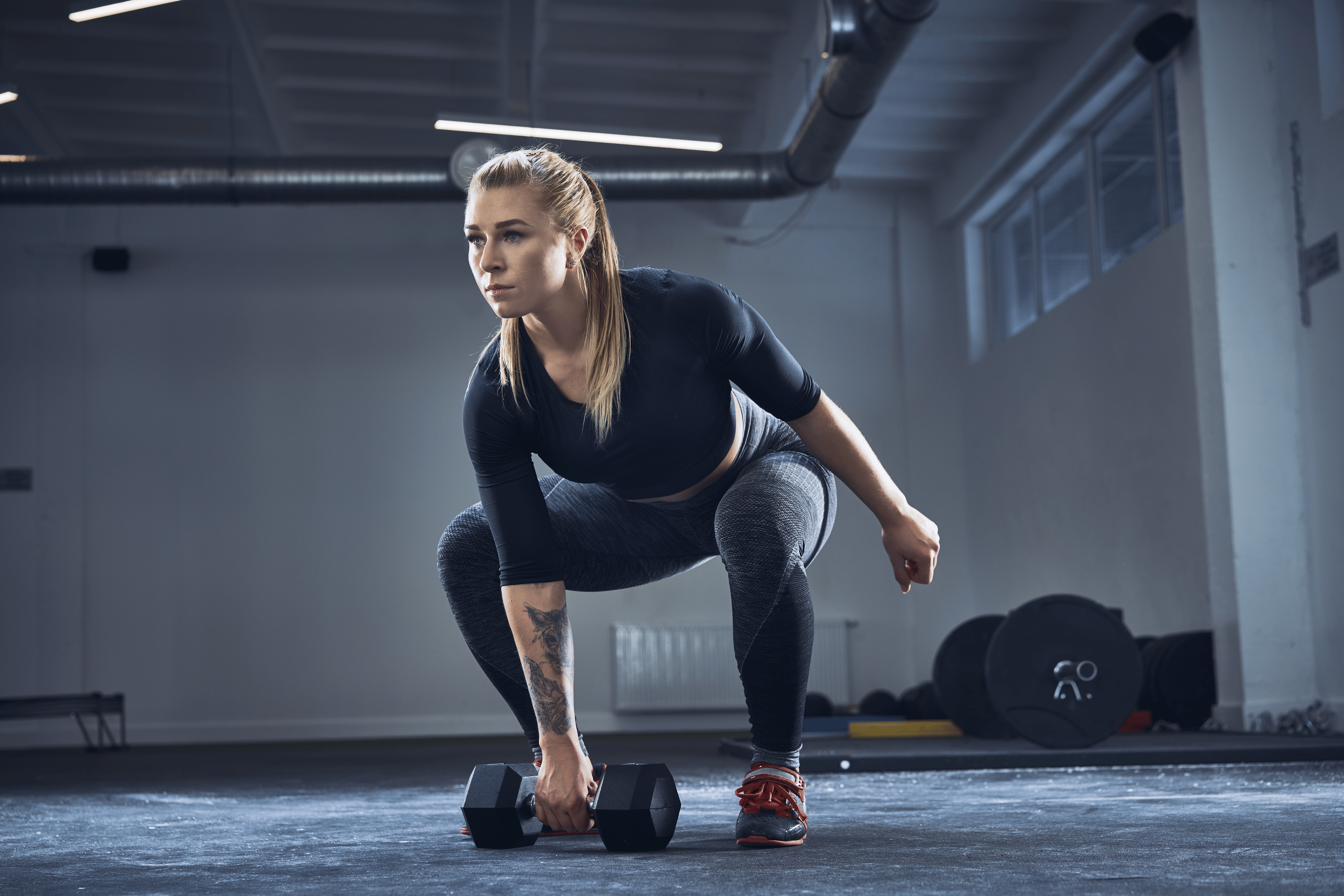 Woman doing a dumbbell snatch exercise 