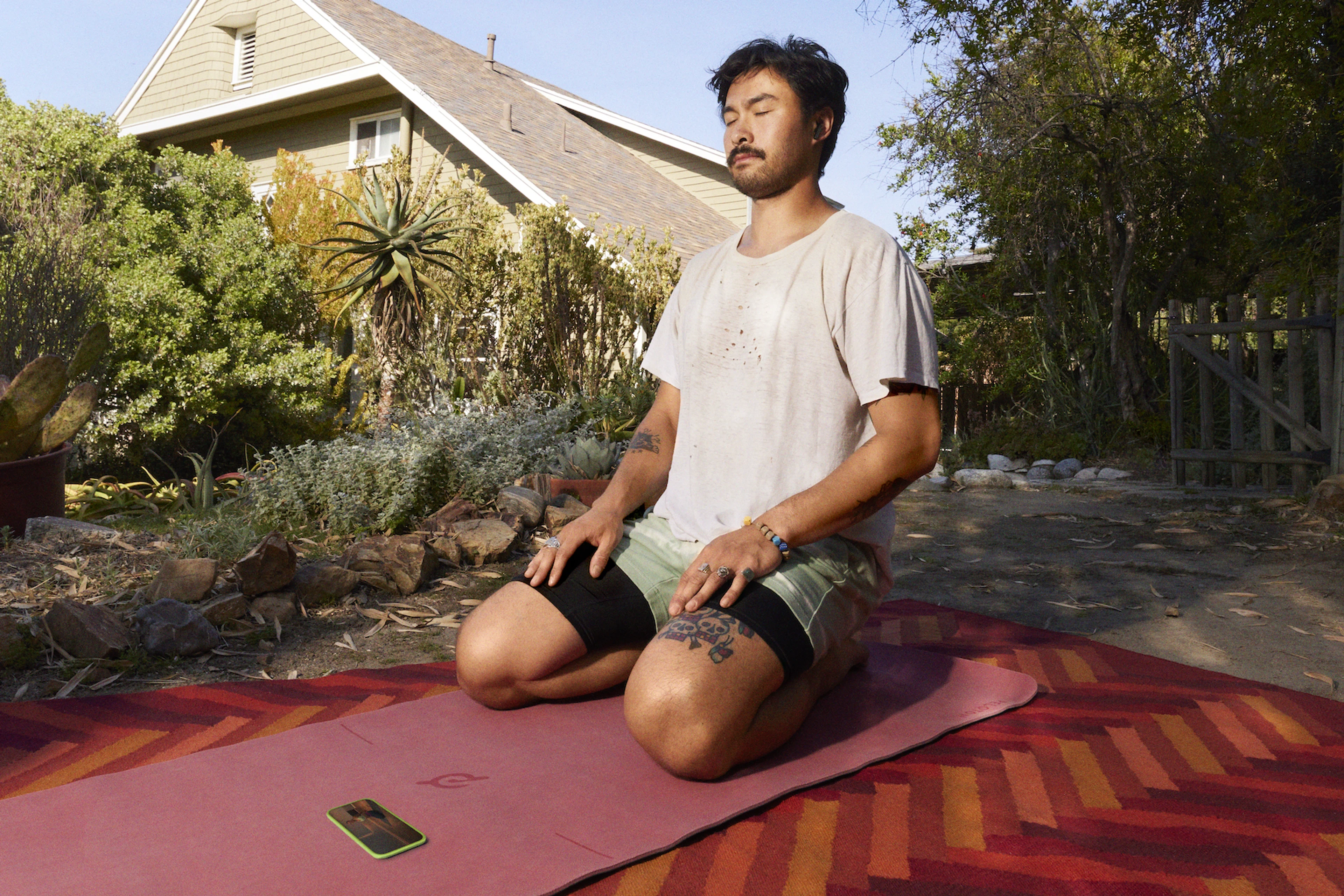 Peloton member working out on a yoga mat outside