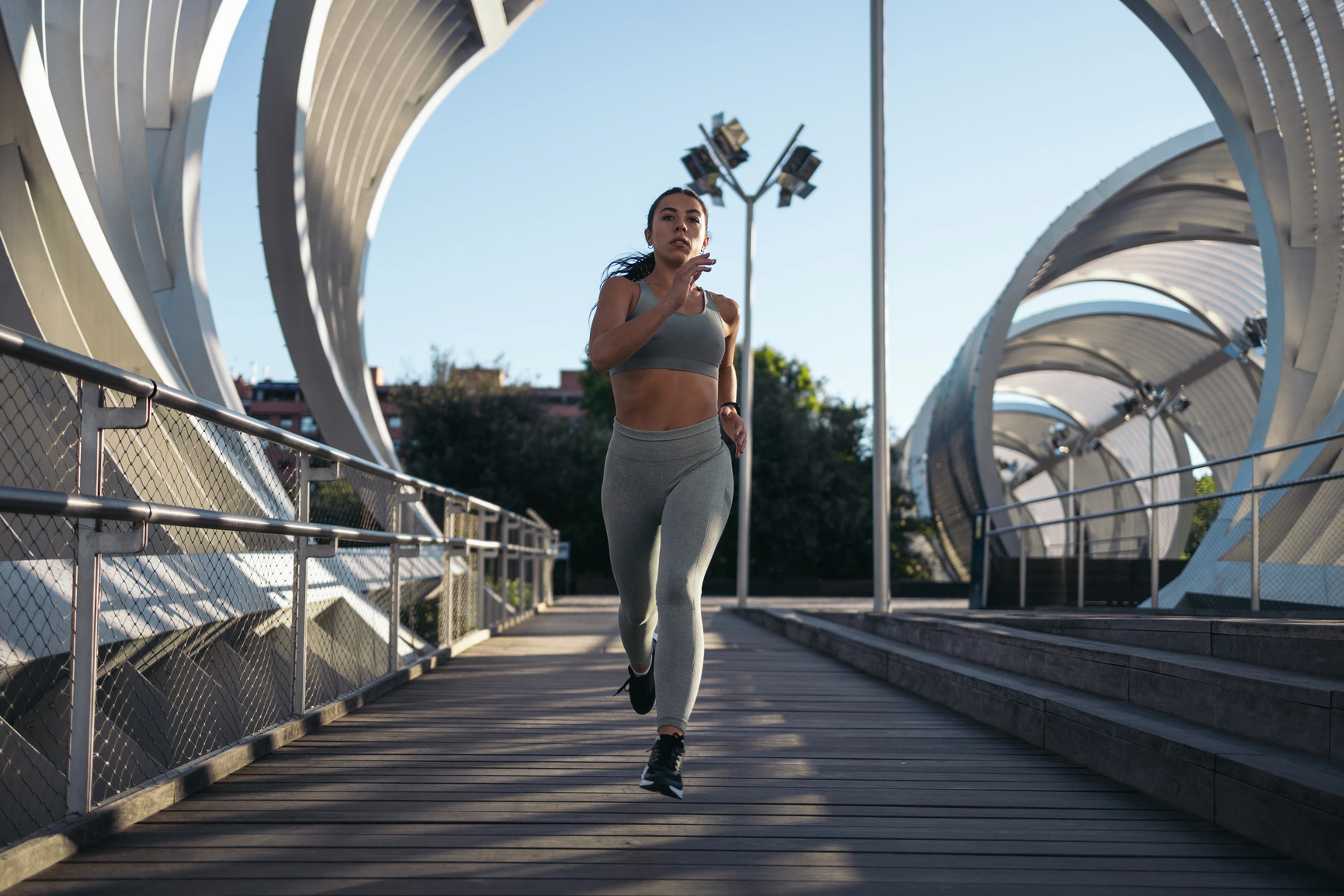 Woman running through city bridge