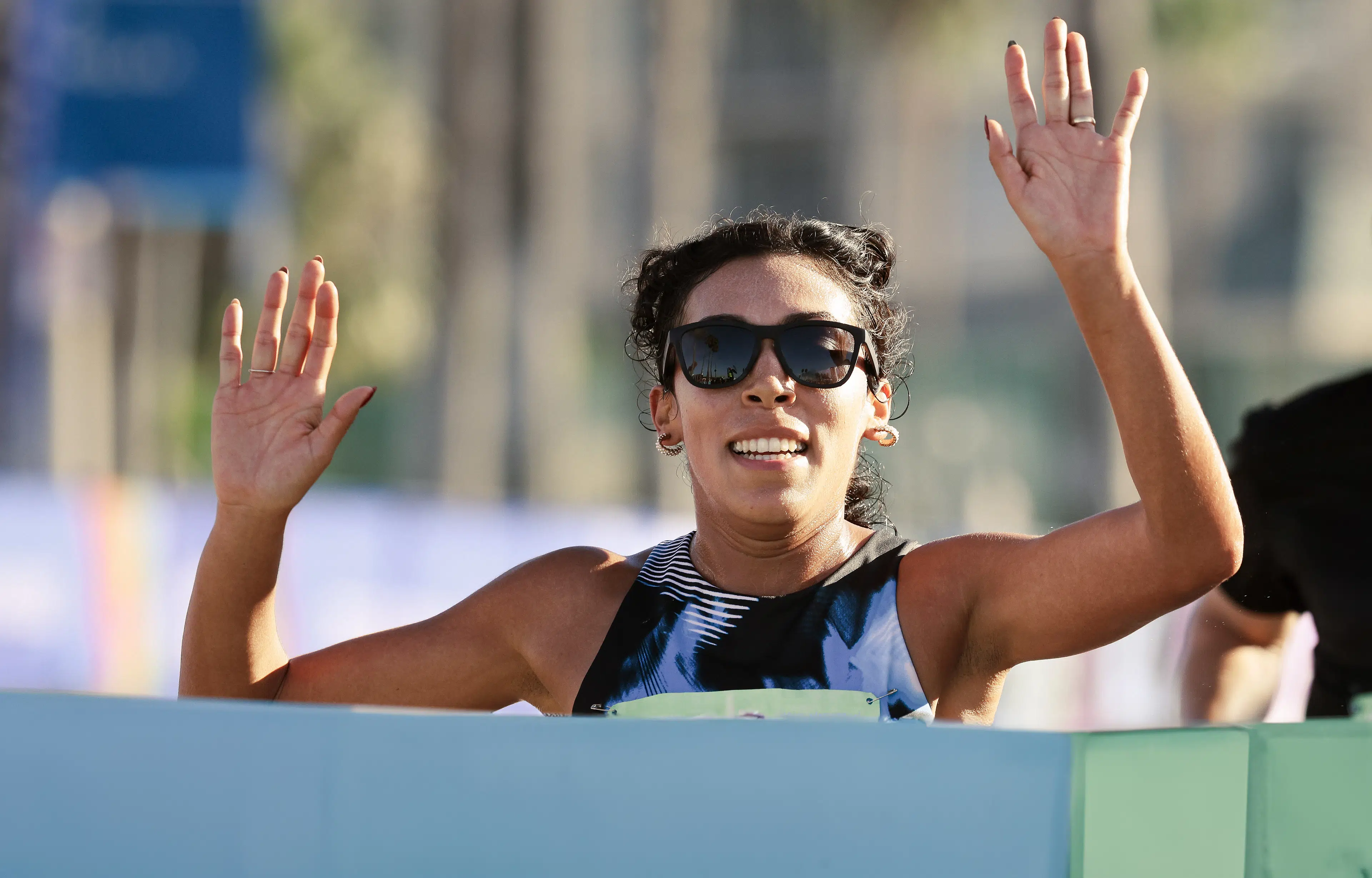 Woman crossing the finish line of a race after setting a running goal.