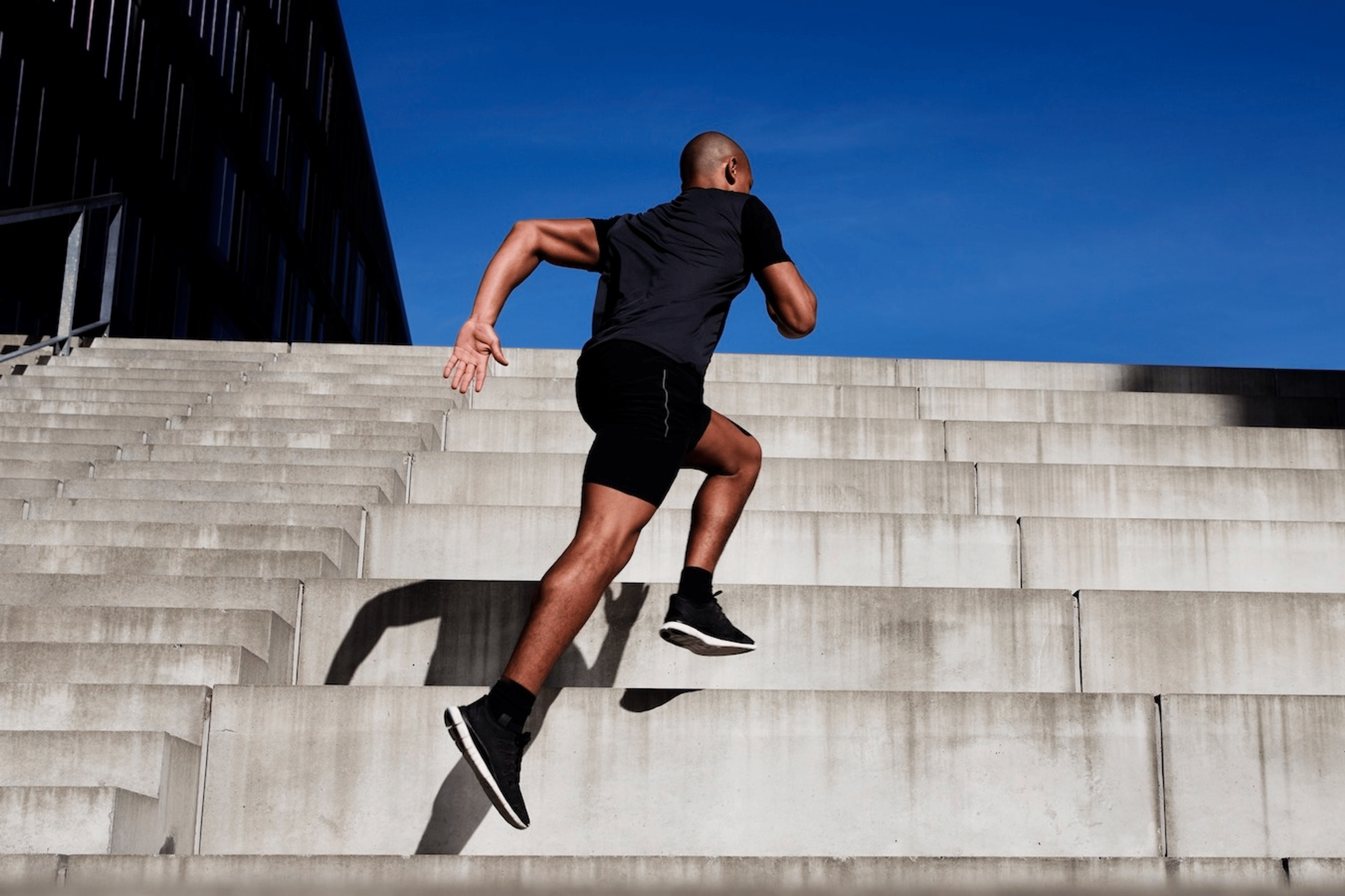 A man running up a set of outdoor stairs for exercise.