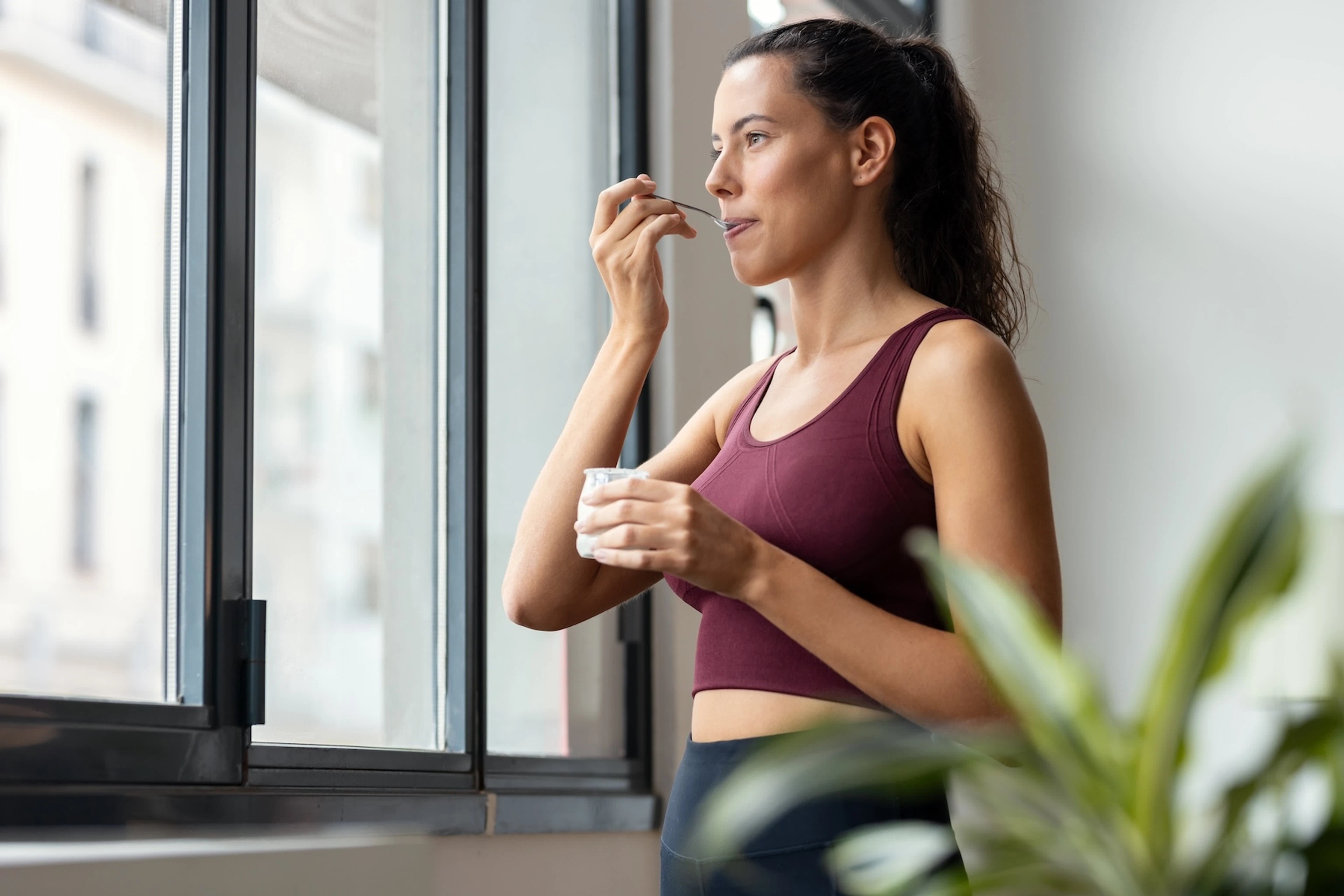 A view of a woman eating Greek yogurt after an endurance run.