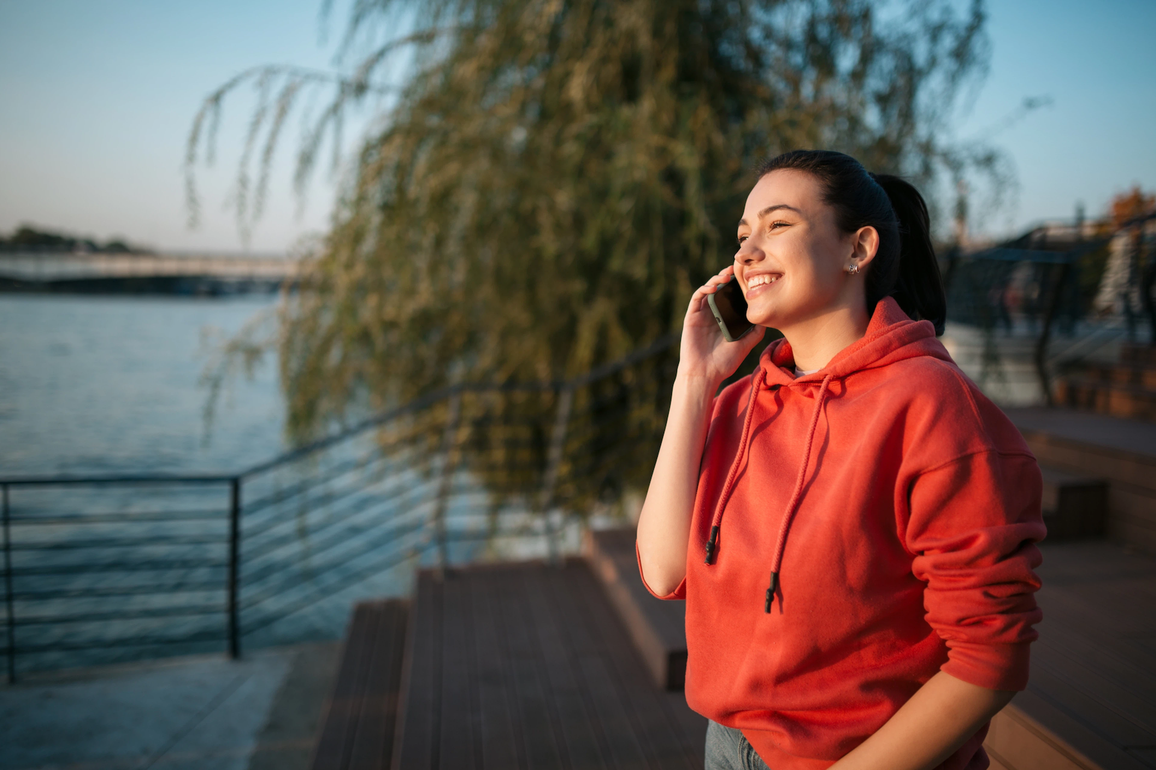 A woman habit stacking by talking on the phone and walking outside at the same time.
