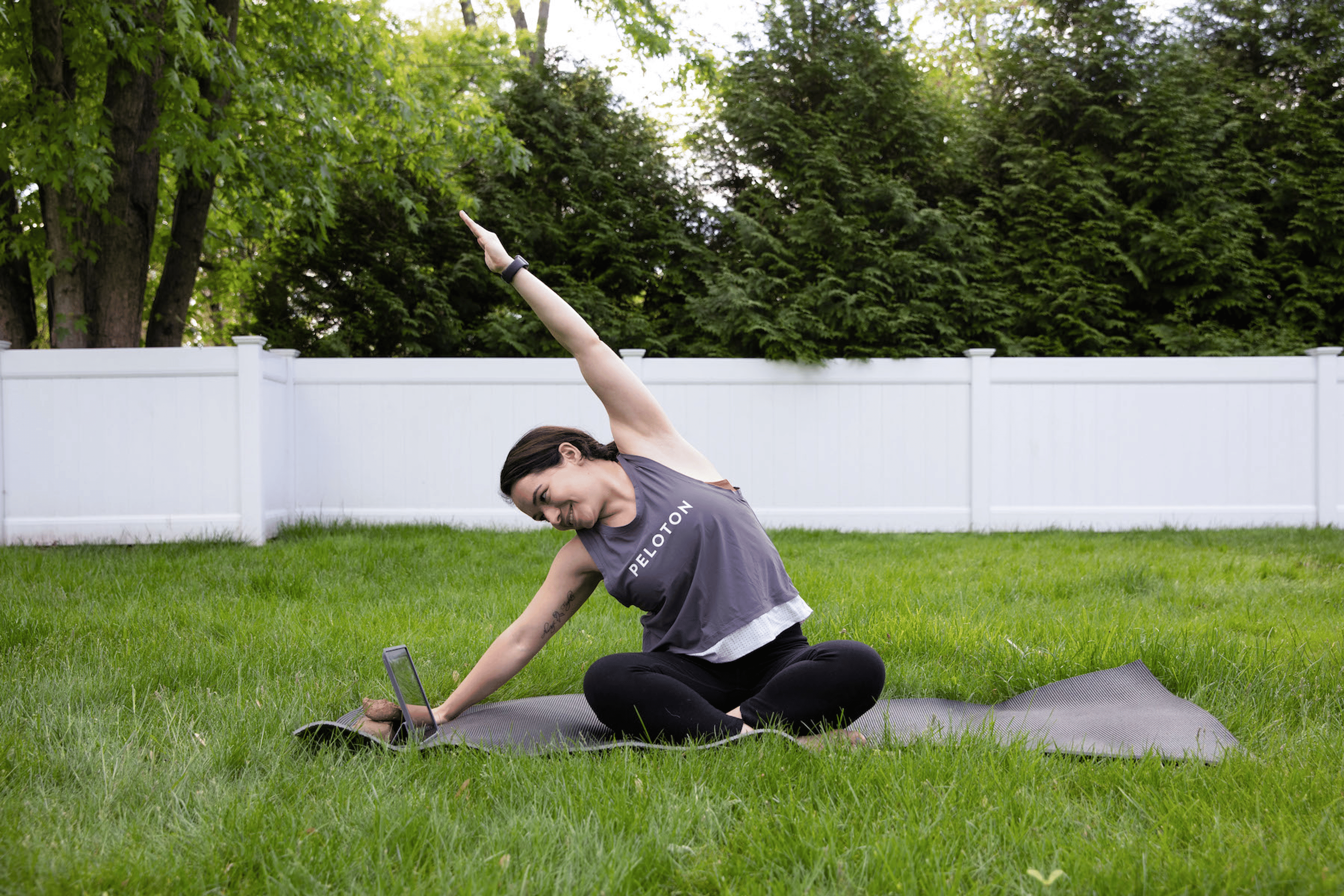 Woman does a side stretch while seated outdoors