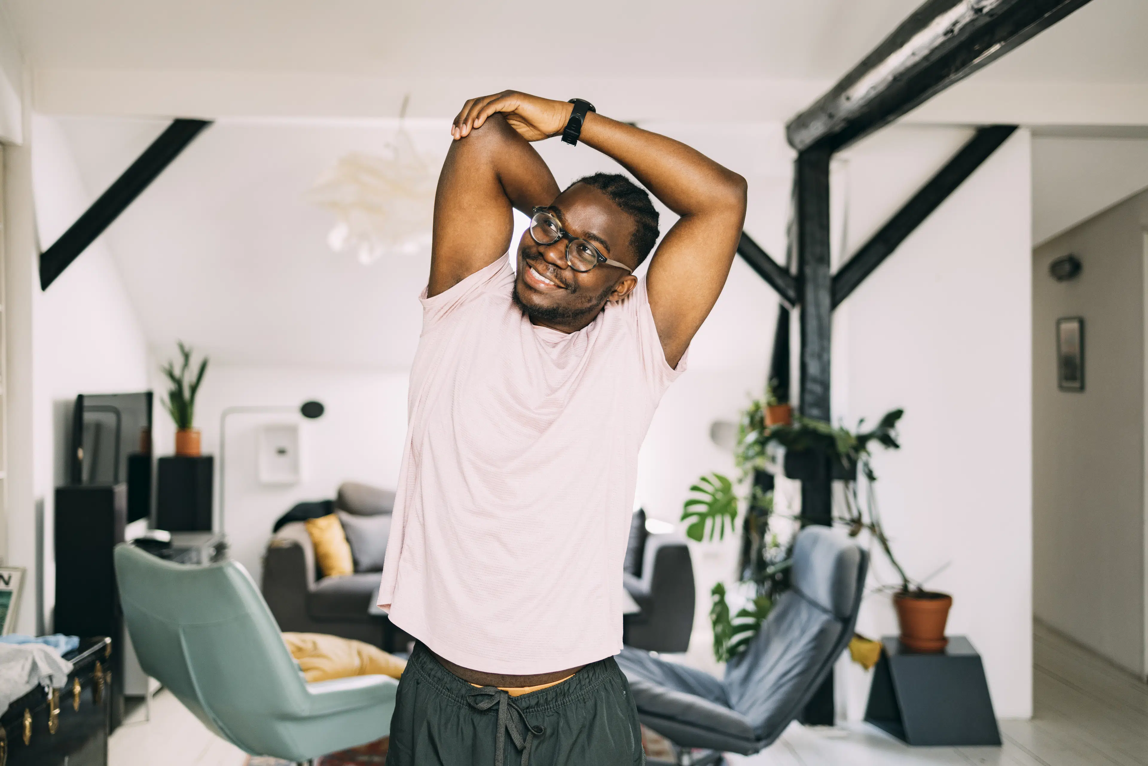 Man at home doing standing stretches to loosen up during the work day.