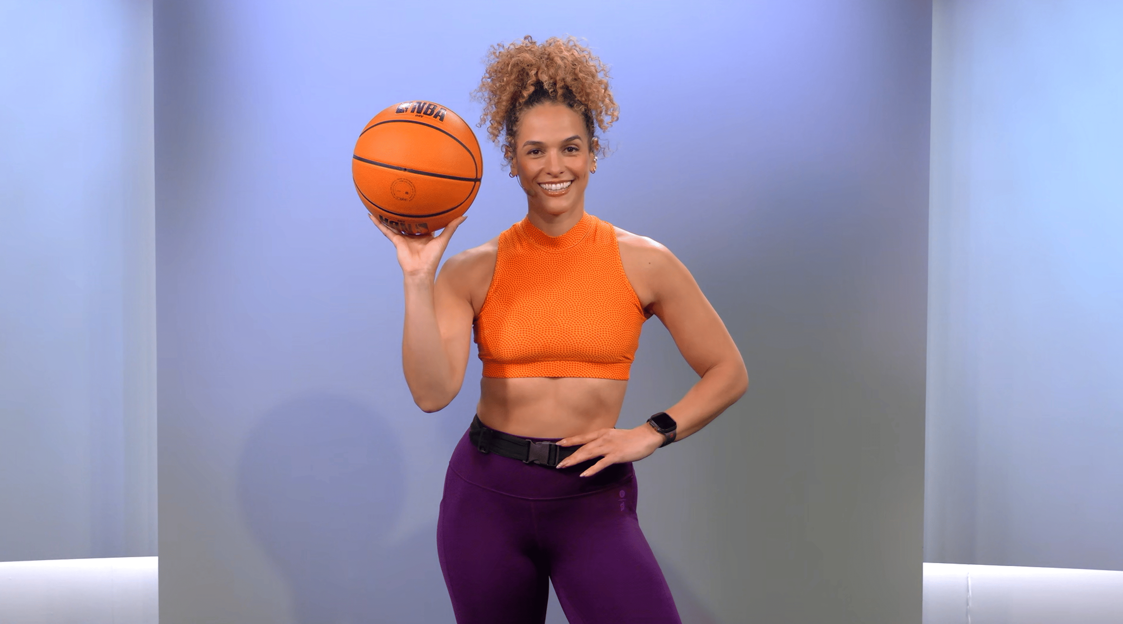 Peloton instructor Jess Sims poses with a basketball for her strength for basketball program on the Peloton App