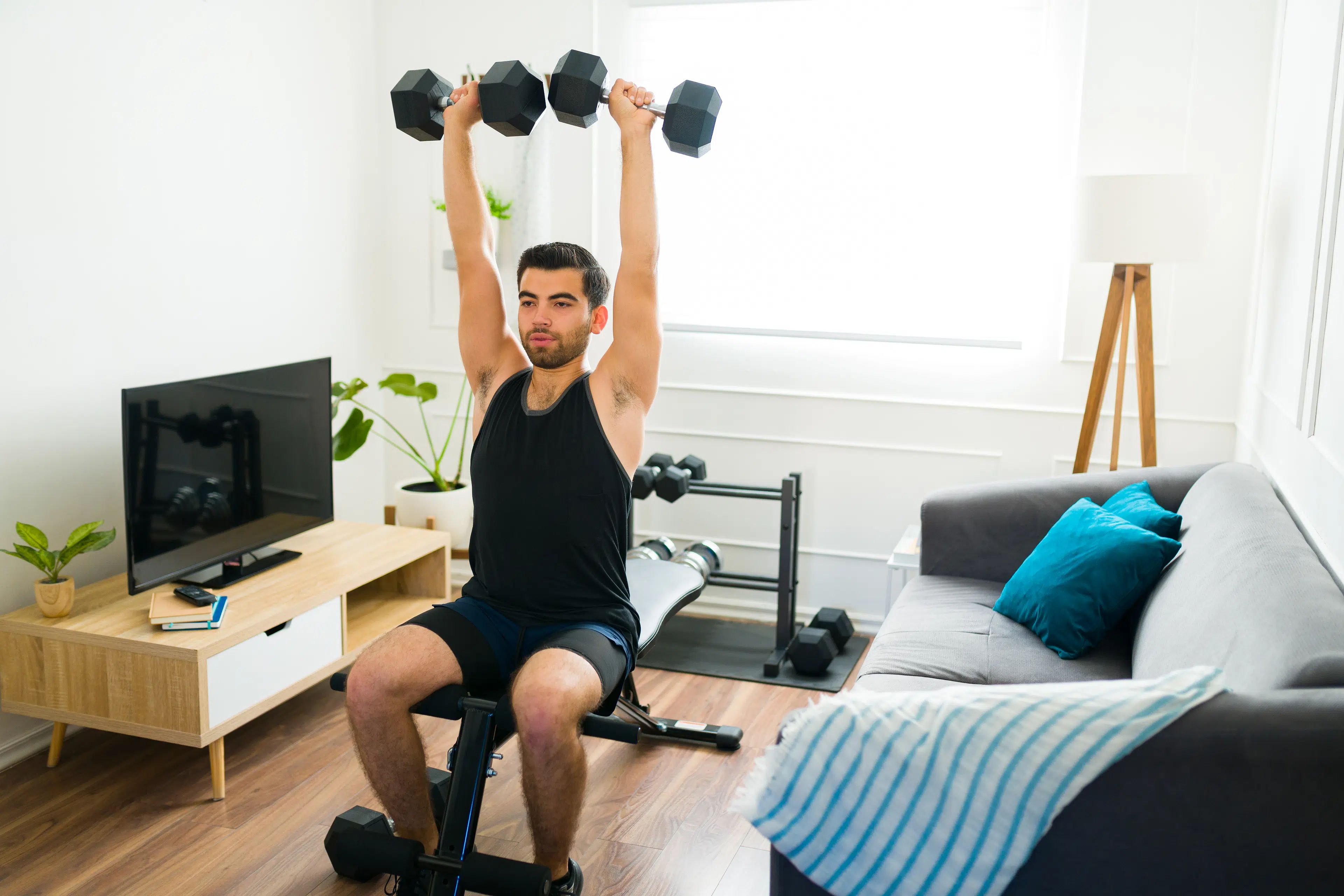 Man lifts weights at home