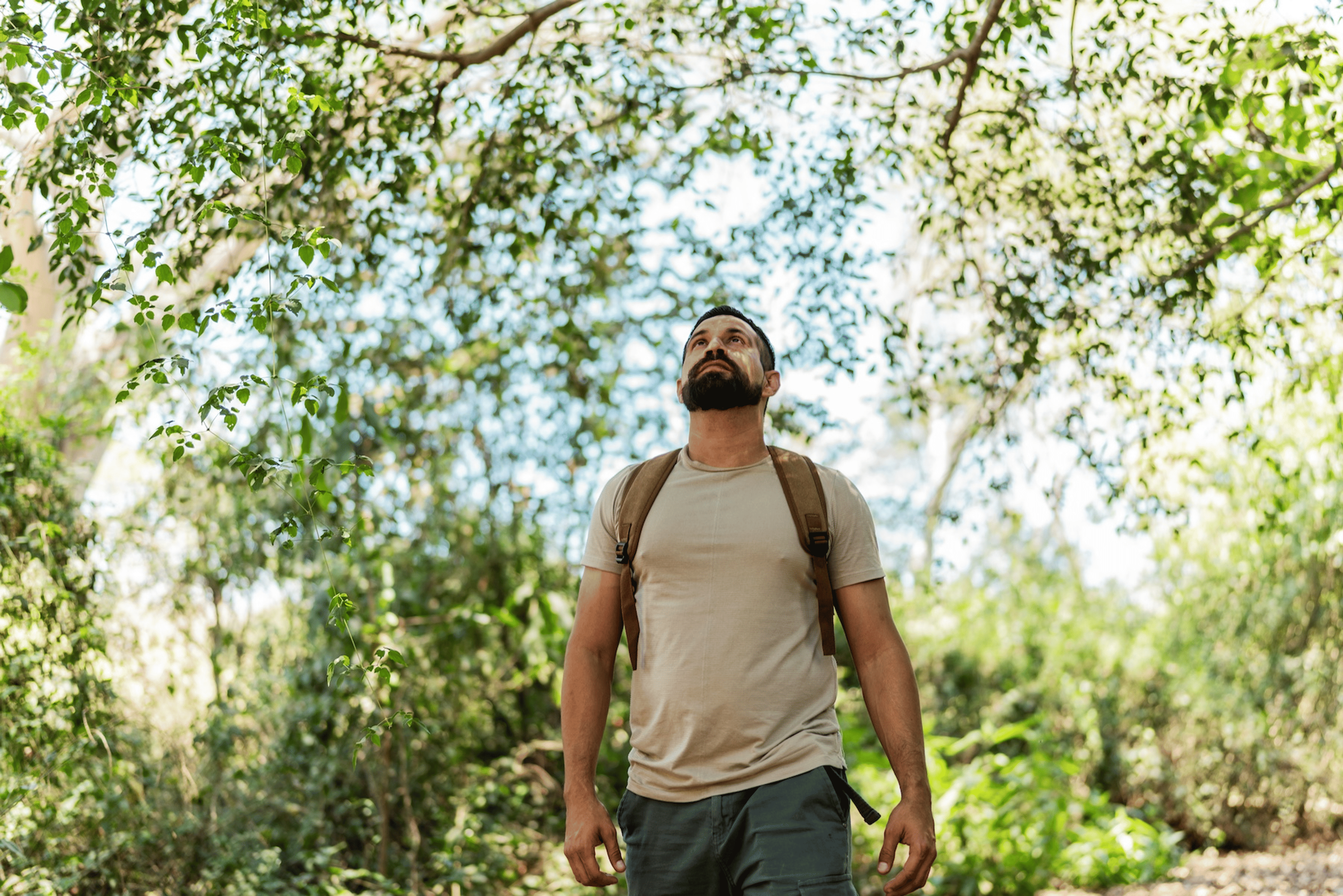 A man going for a walk in the park in the afternoon.