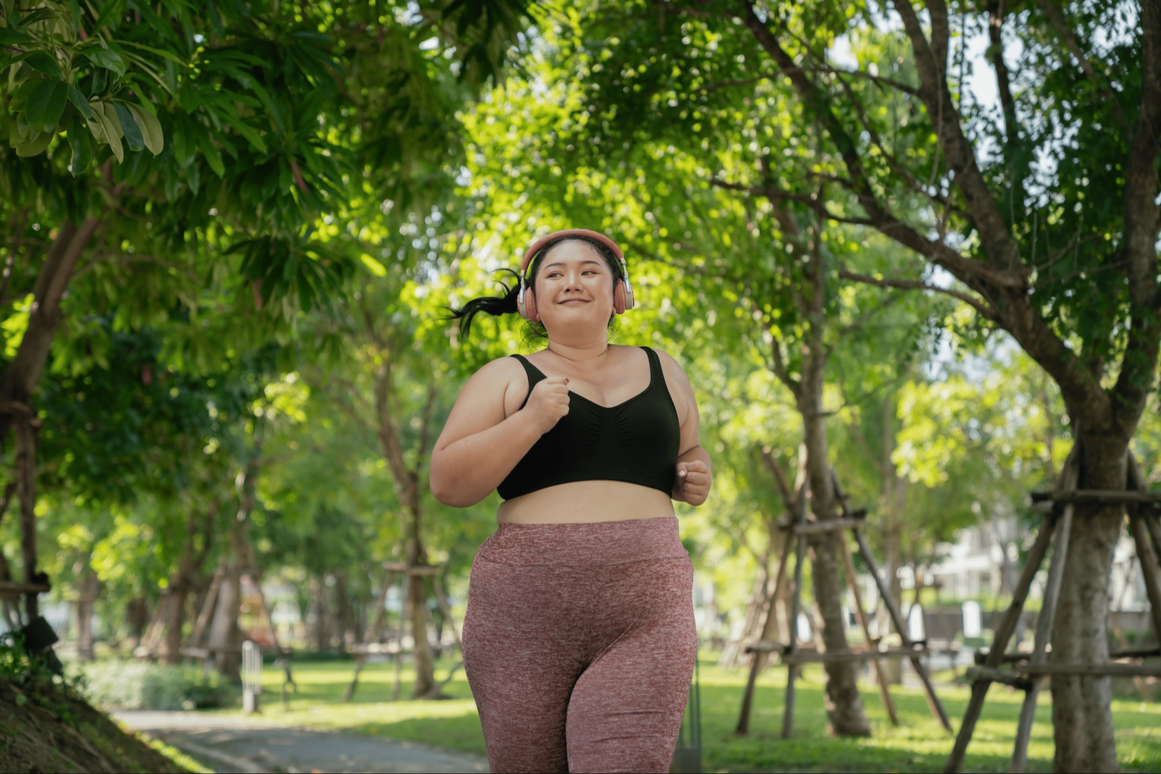 A woman going for an outdoor jog through a park as part of her morning routine.