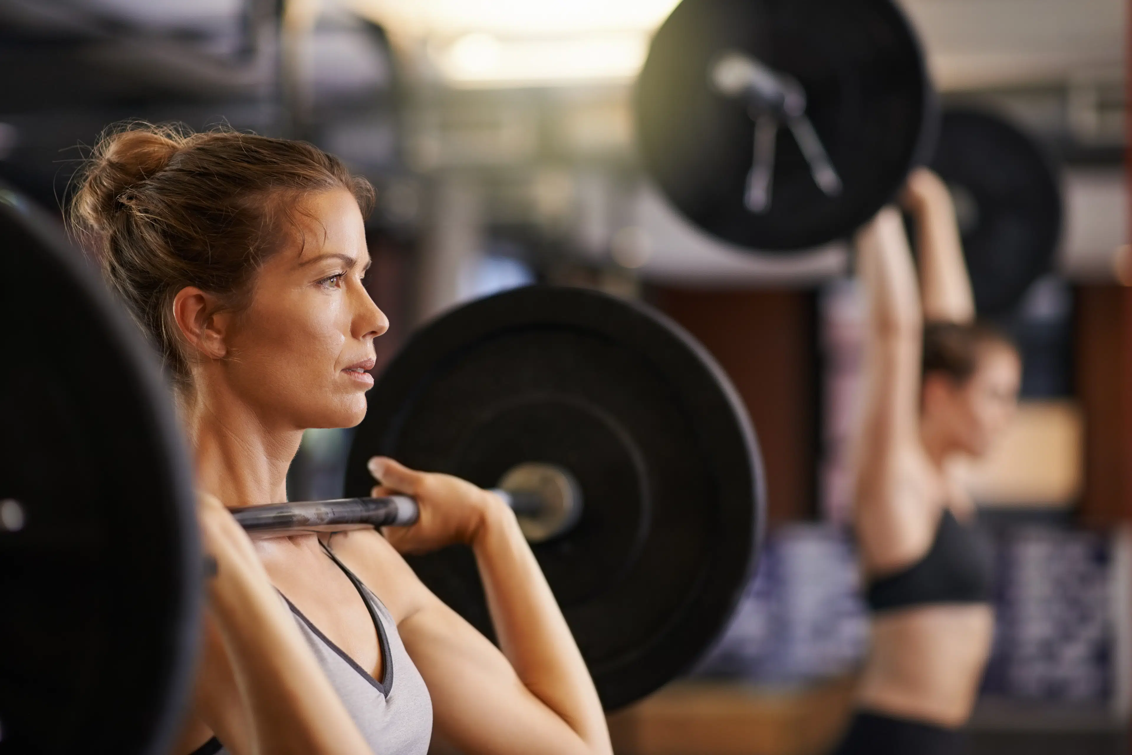 Woman lifts a heavy barbell, one rep max 