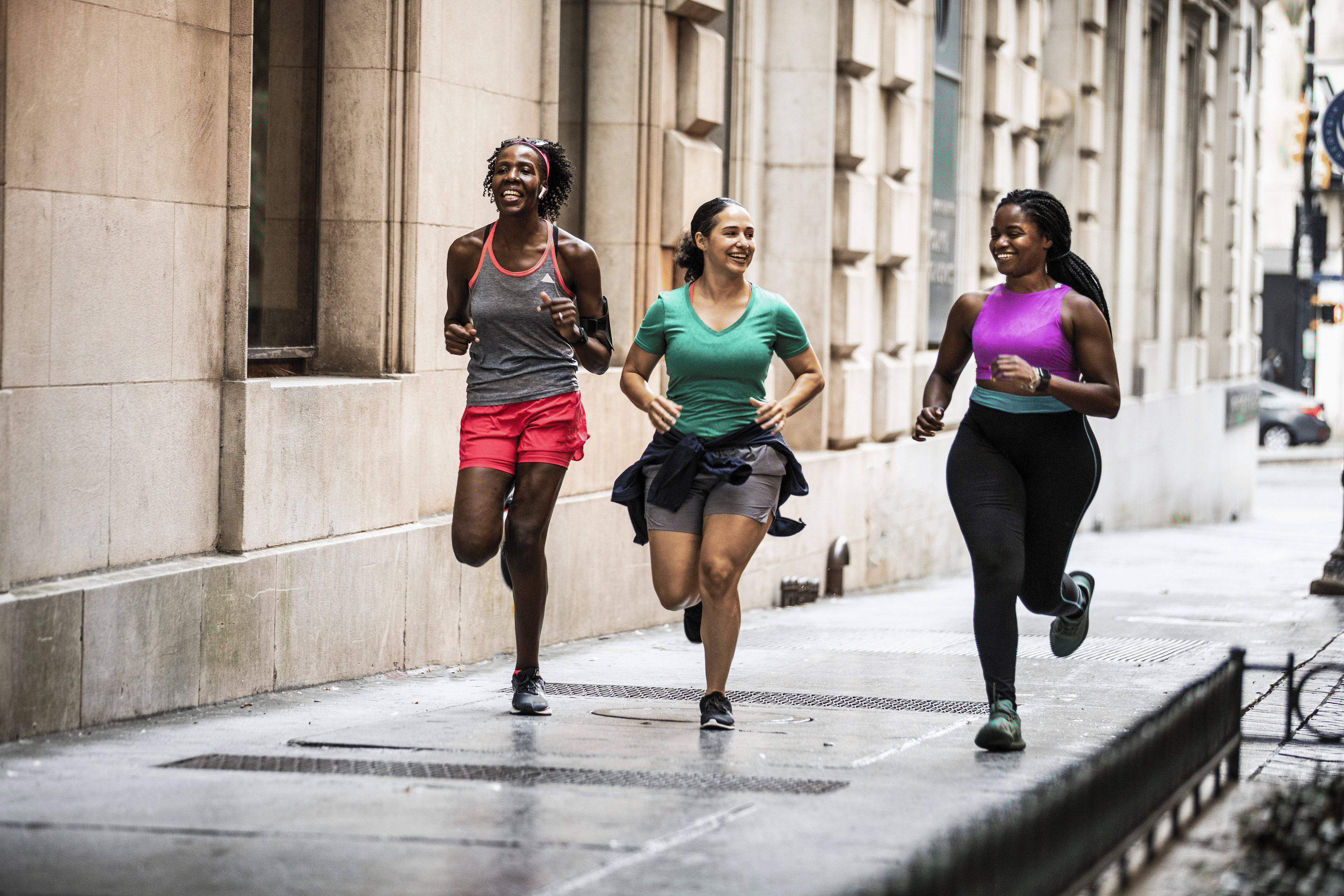 Group of women running through urban area