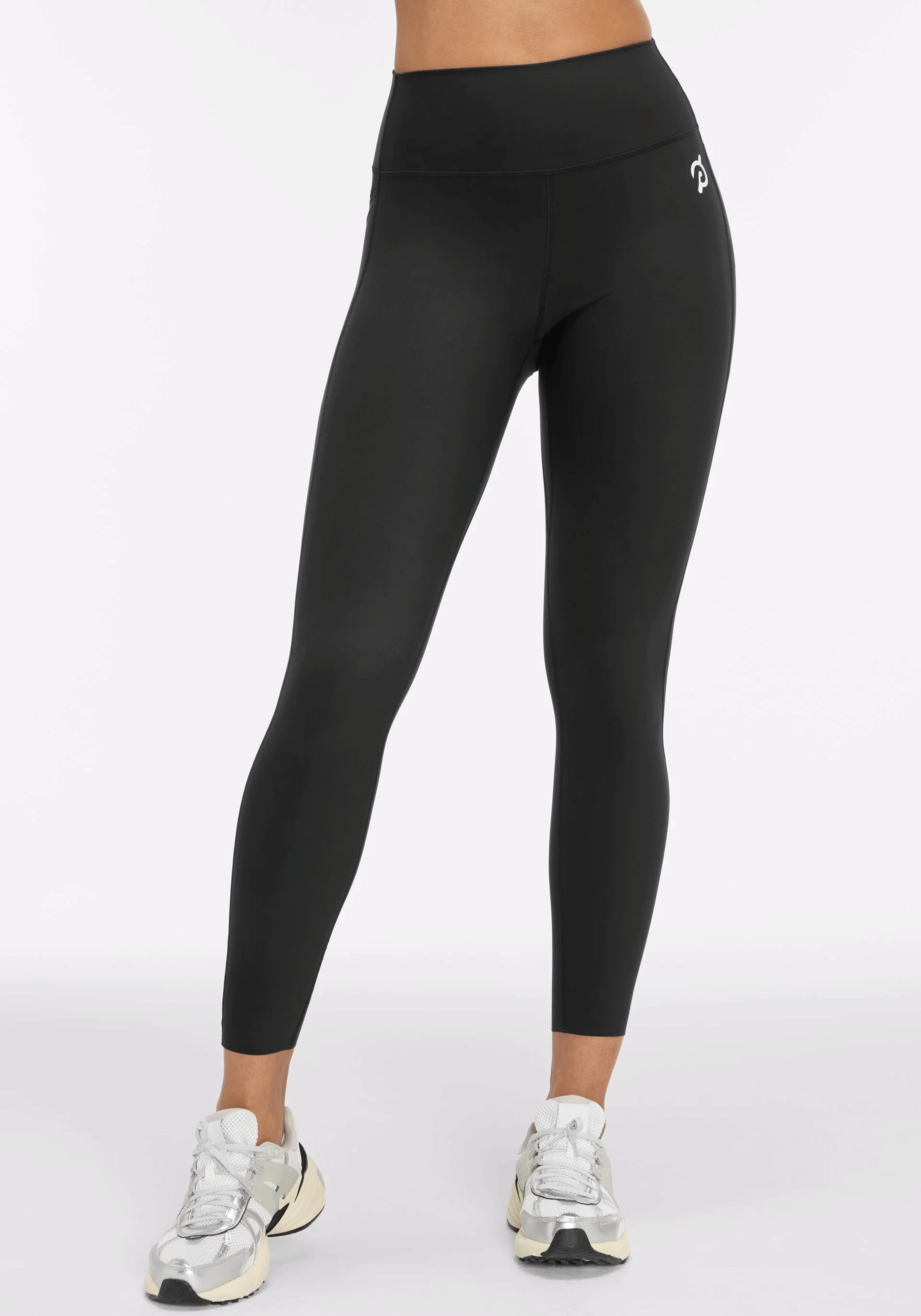 A model wearing a pair of black Peloton Cadent leggings as part of a list of Peloton Bike accessories.