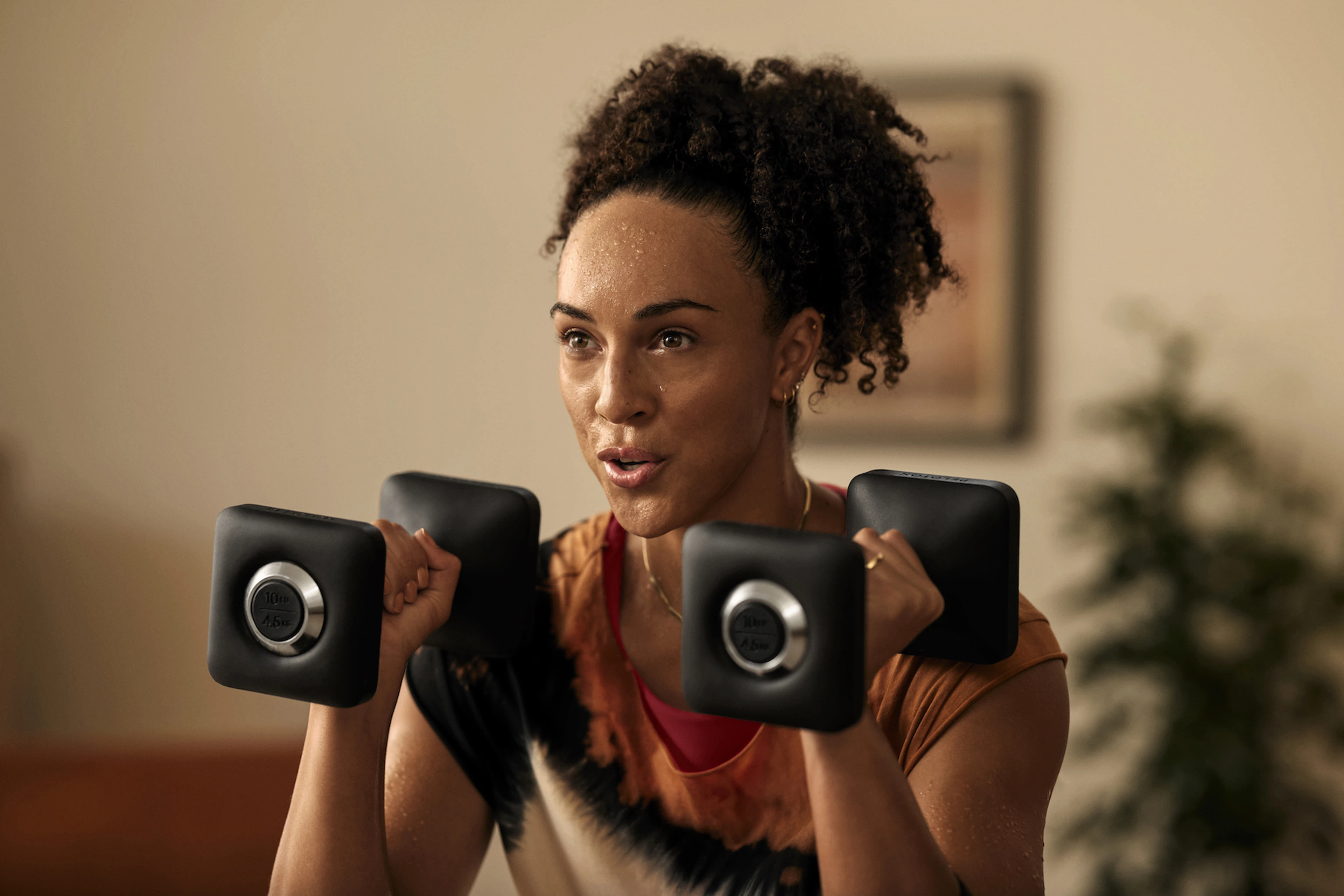 Woman holds two dumbbells 