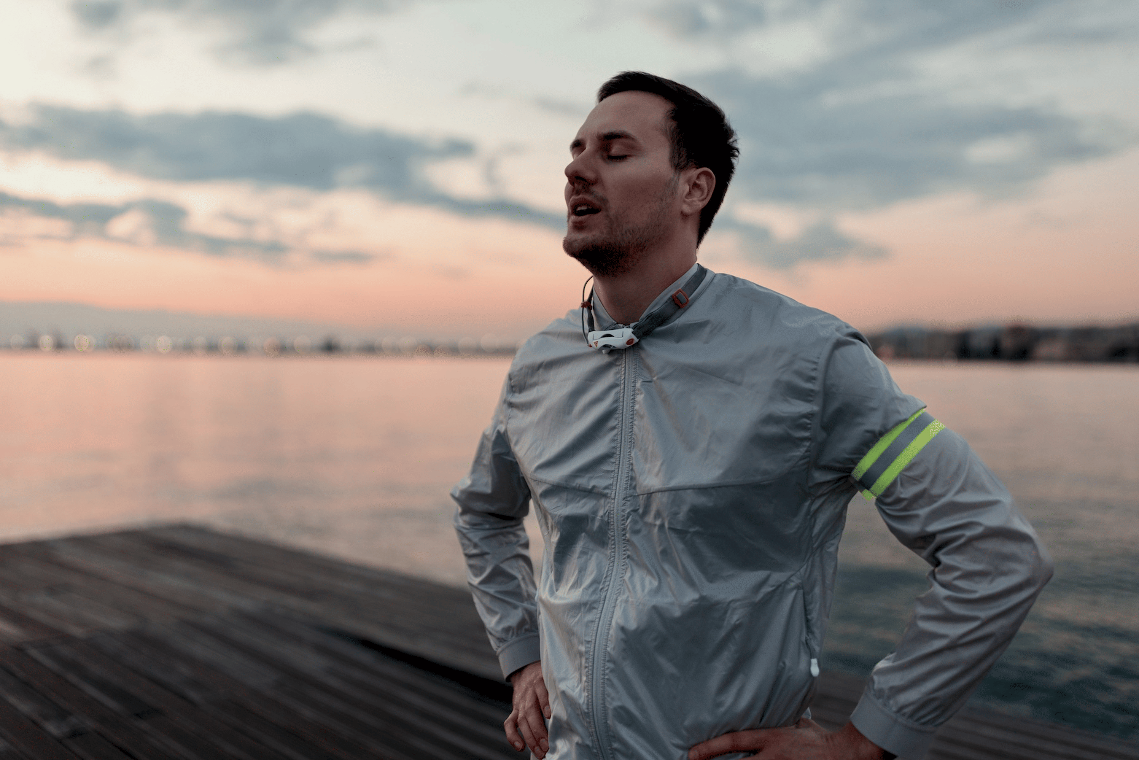 A man breathing and feeling happy after a long morning run outside.