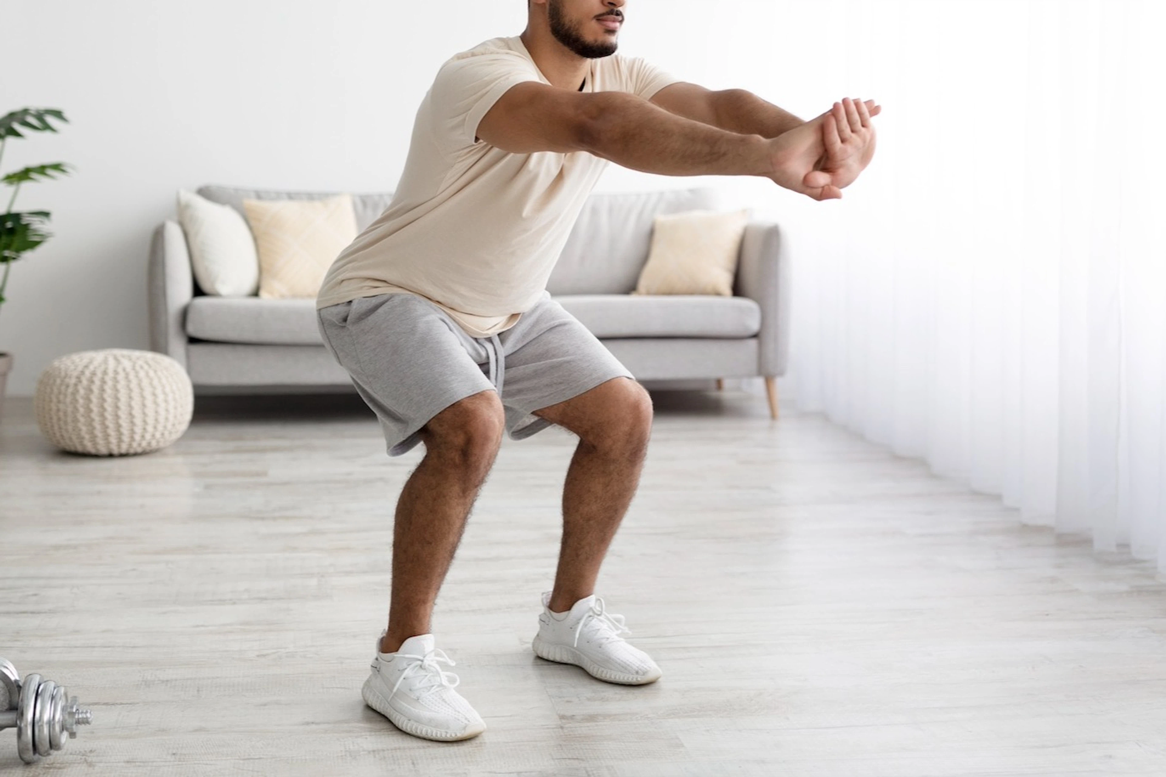 A close-up photo of a man's knees while engaging in a squat.