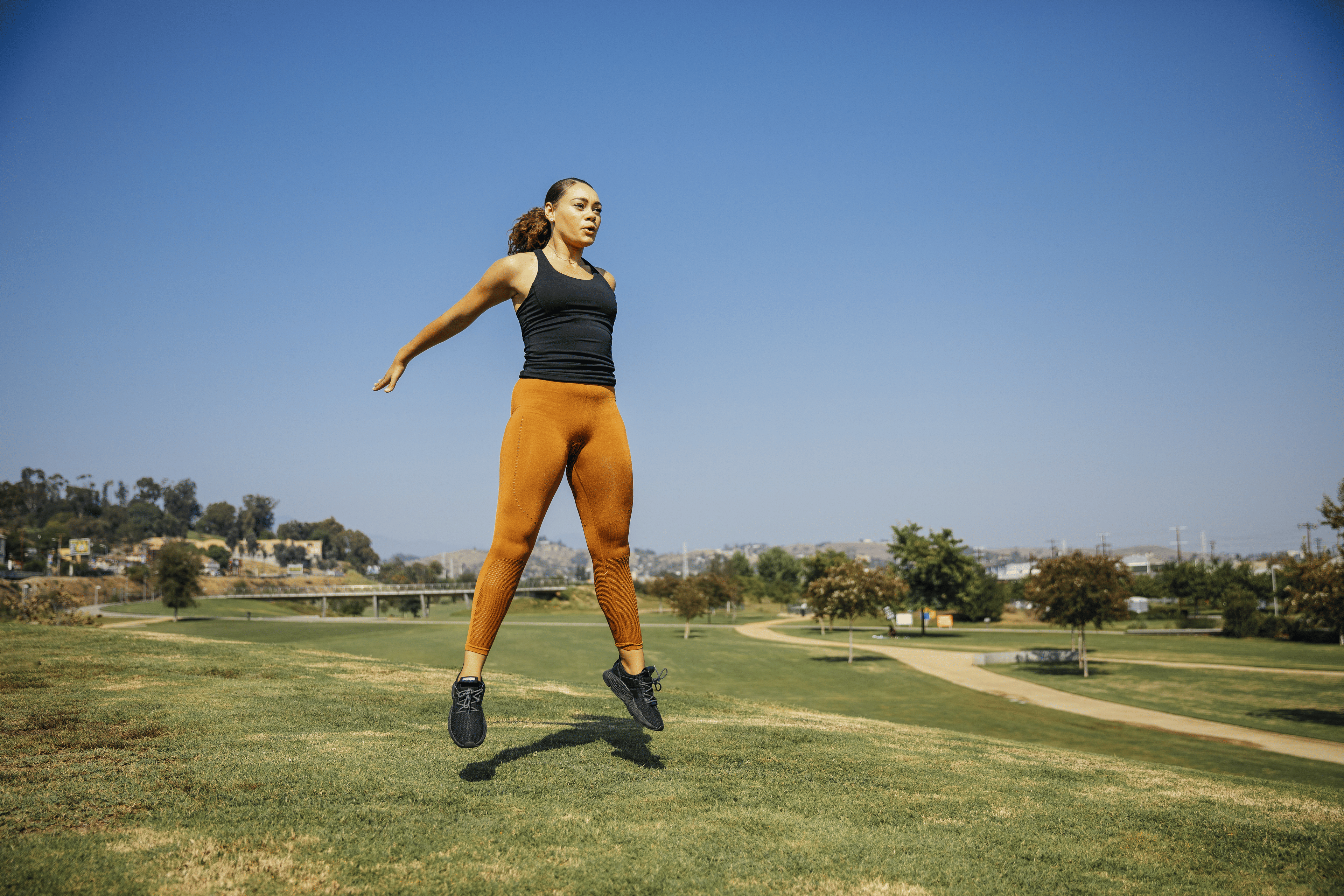 Woman jumping while exercising at outdoor park