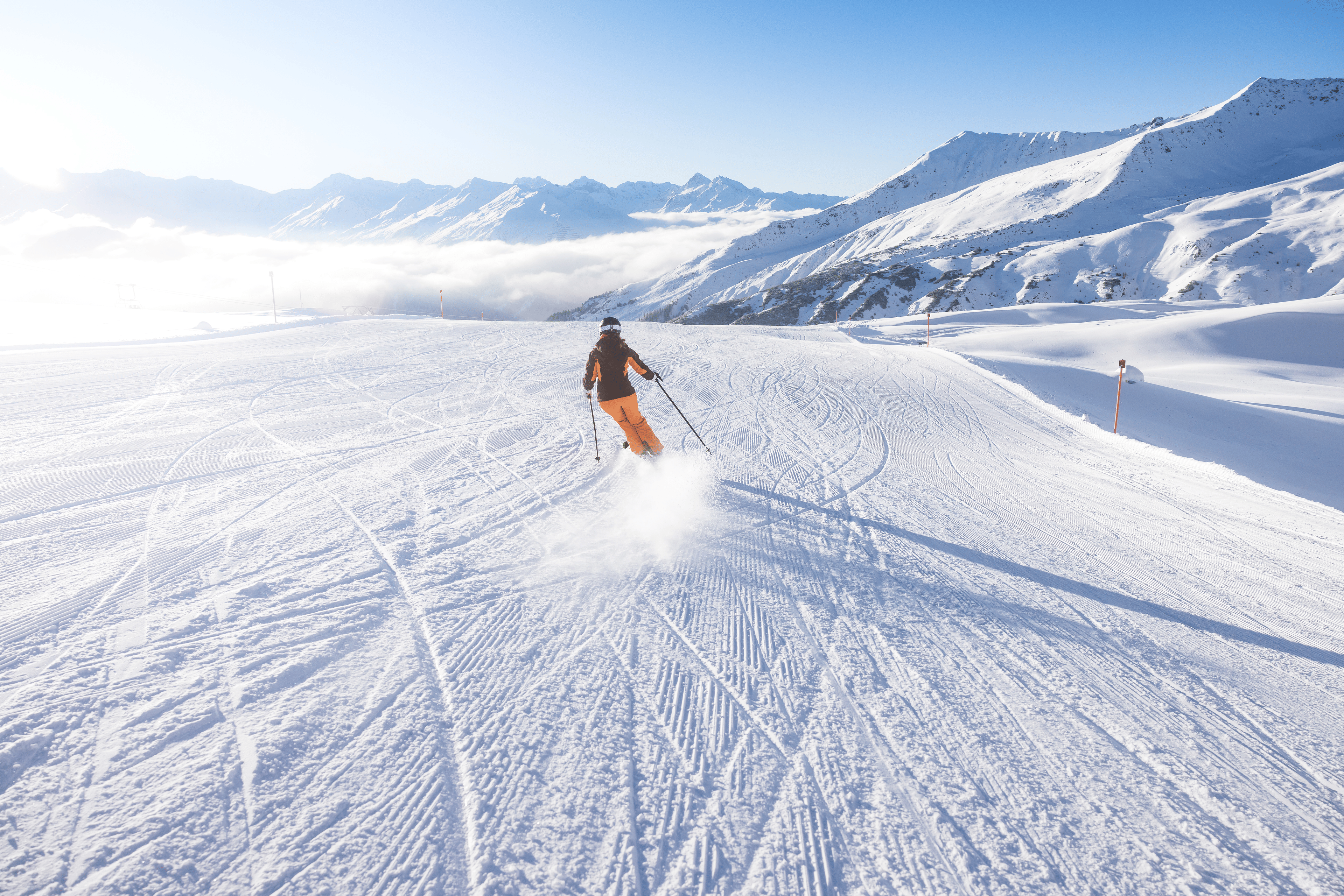 Person skis on a snowy ski slope 