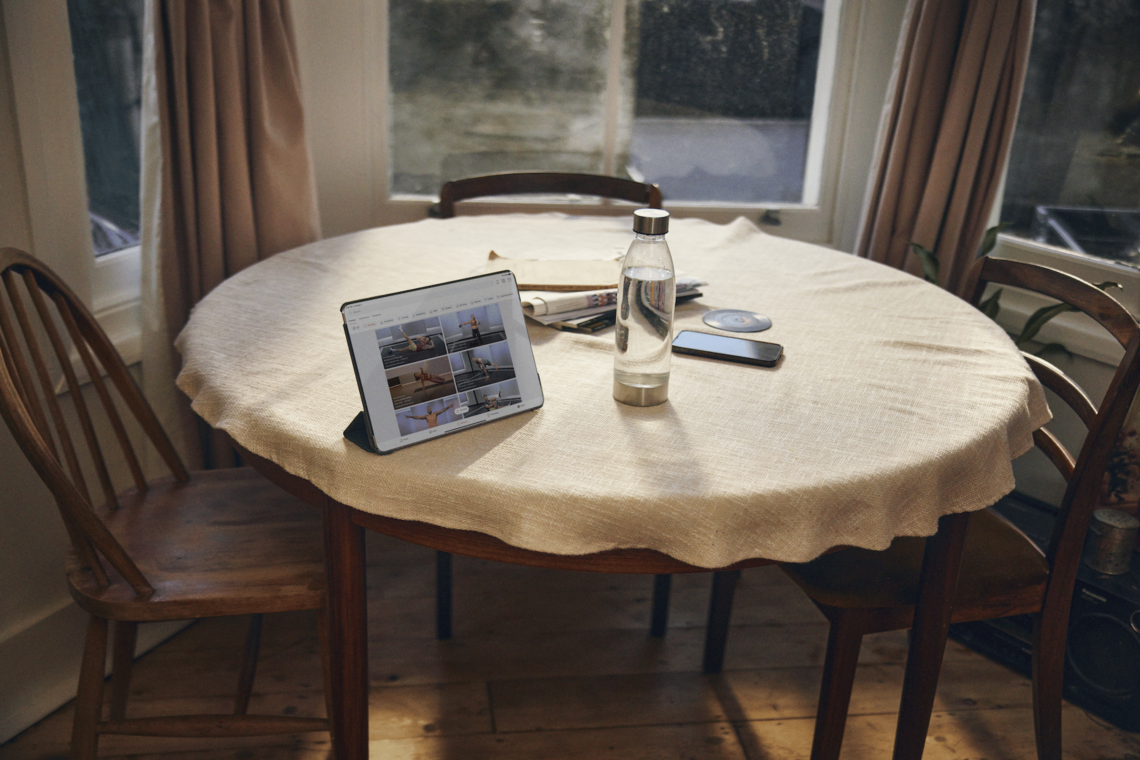 Water bottle sitting next to an iPad with the Peloton App open on the screen