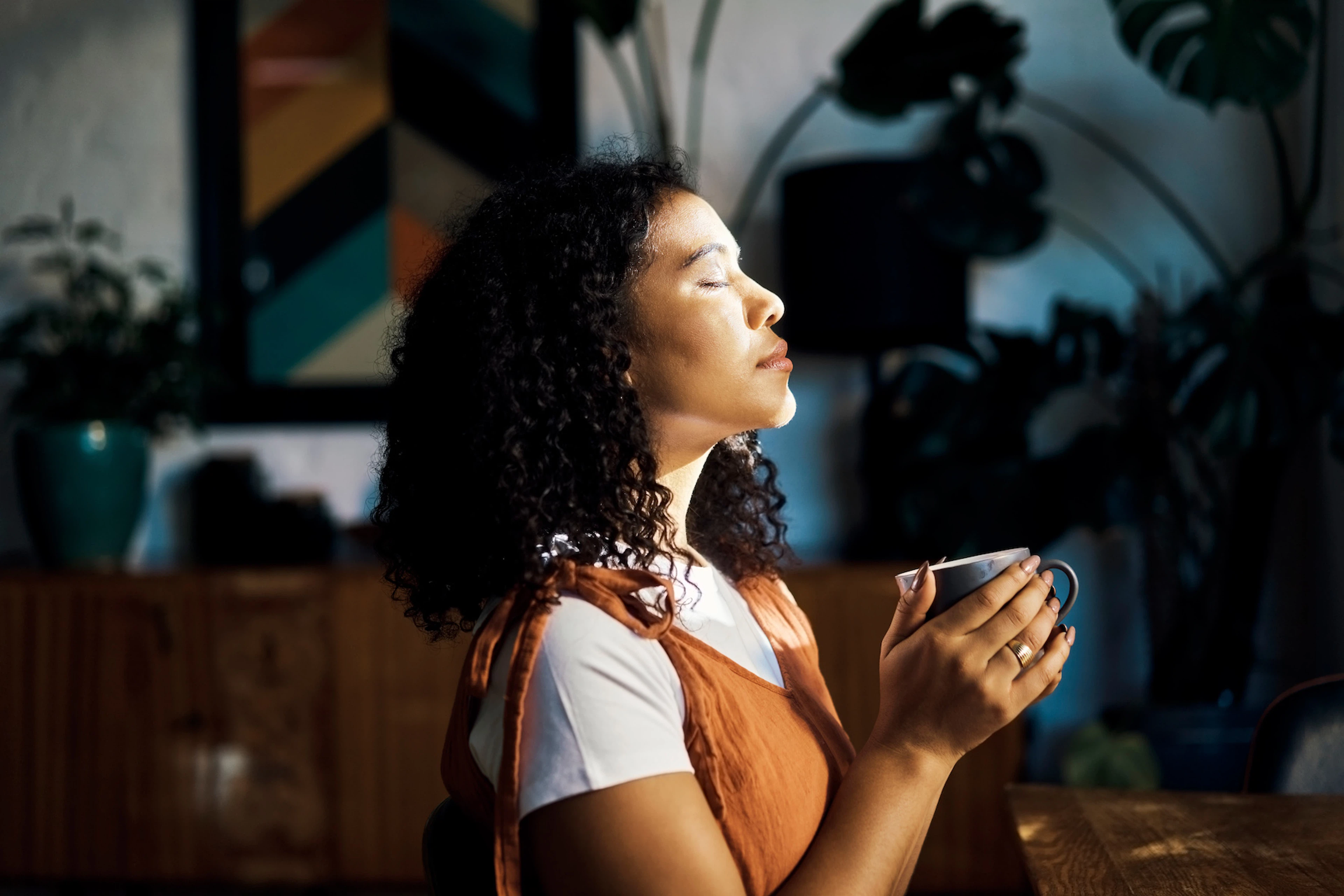 A woman habit stacking by meditating and drinking her coffee at the same time.