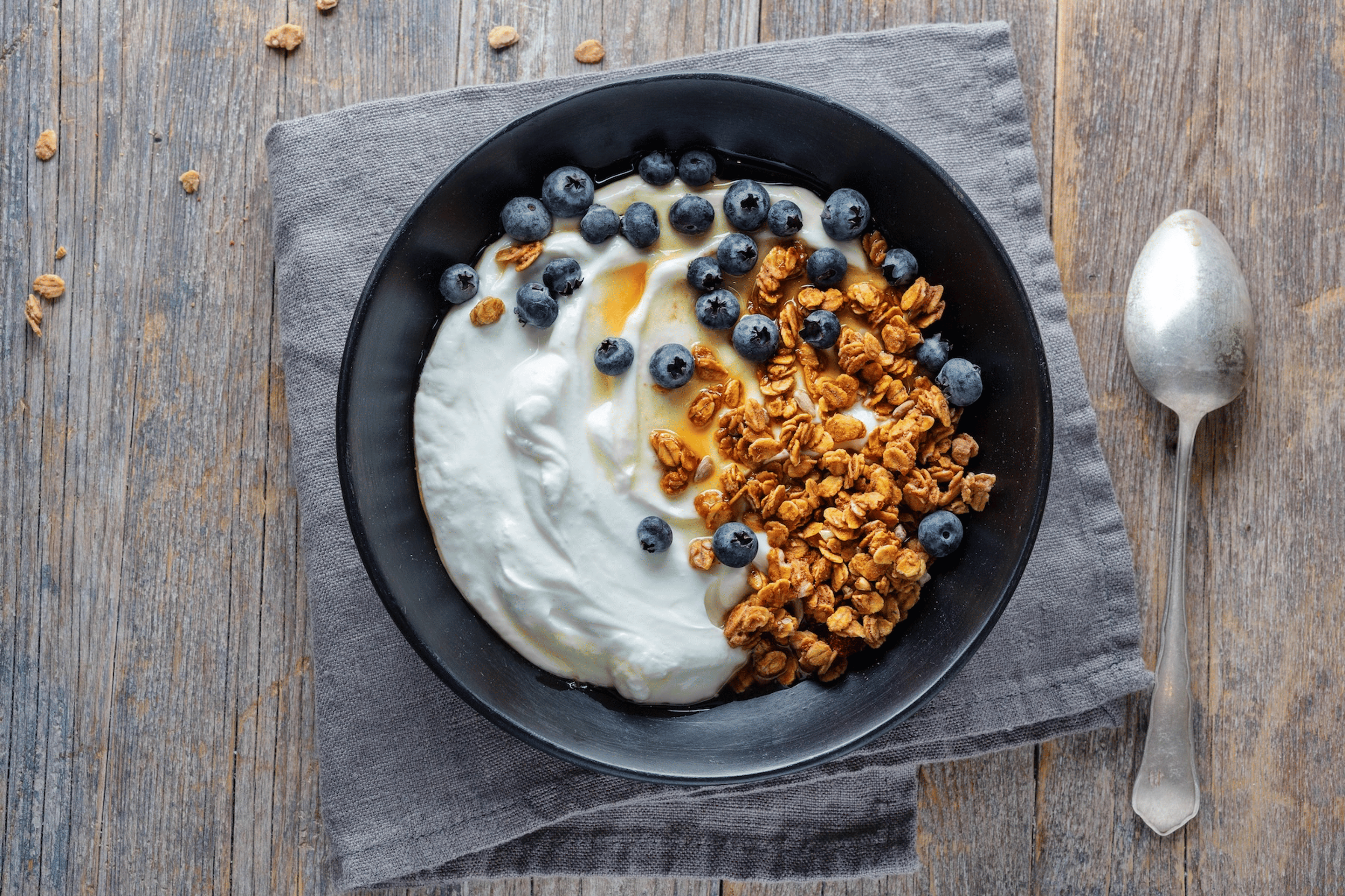 Greek yogurt in a bowl with muesli and blueberries.