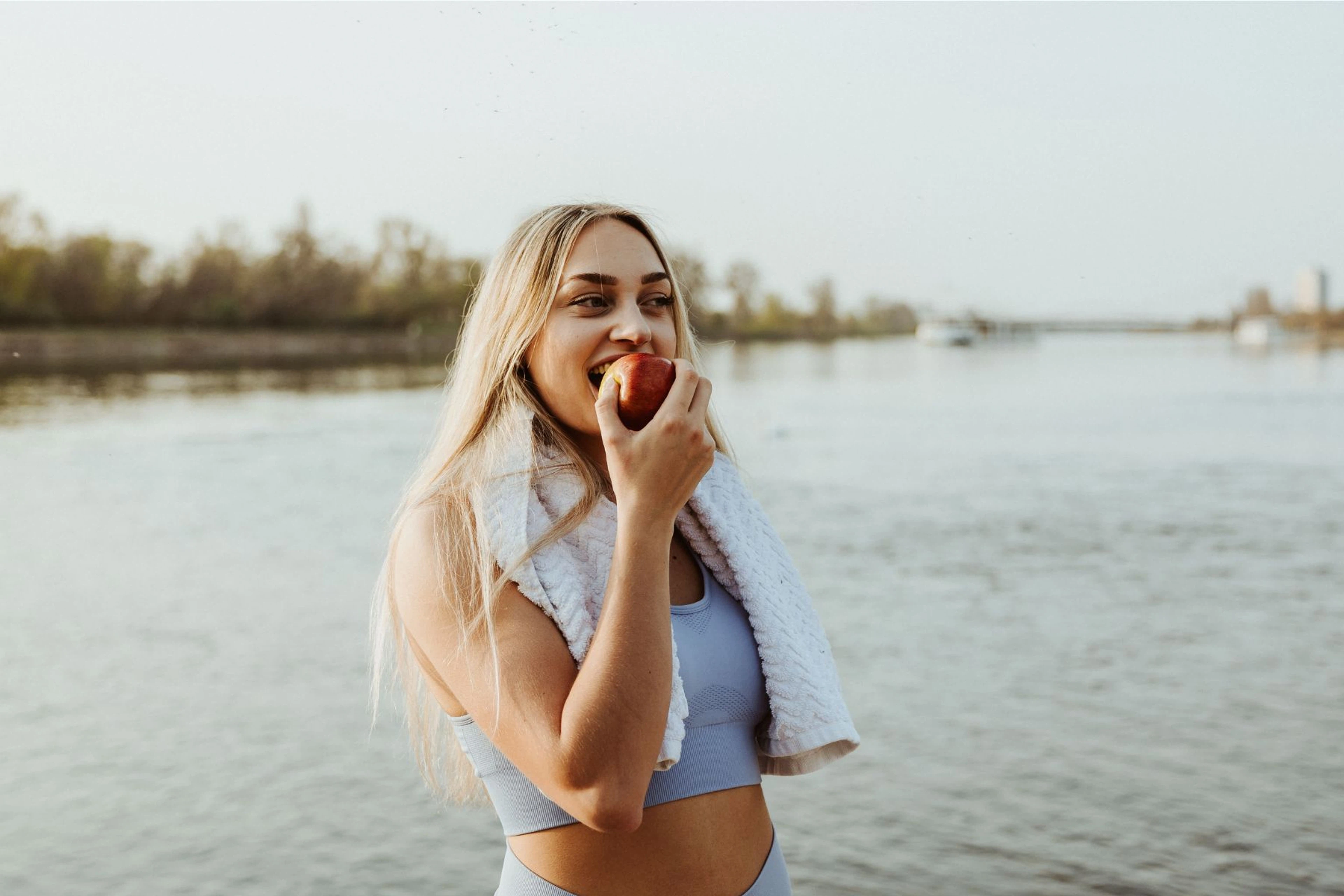 Woman in workout clothes eating an apple