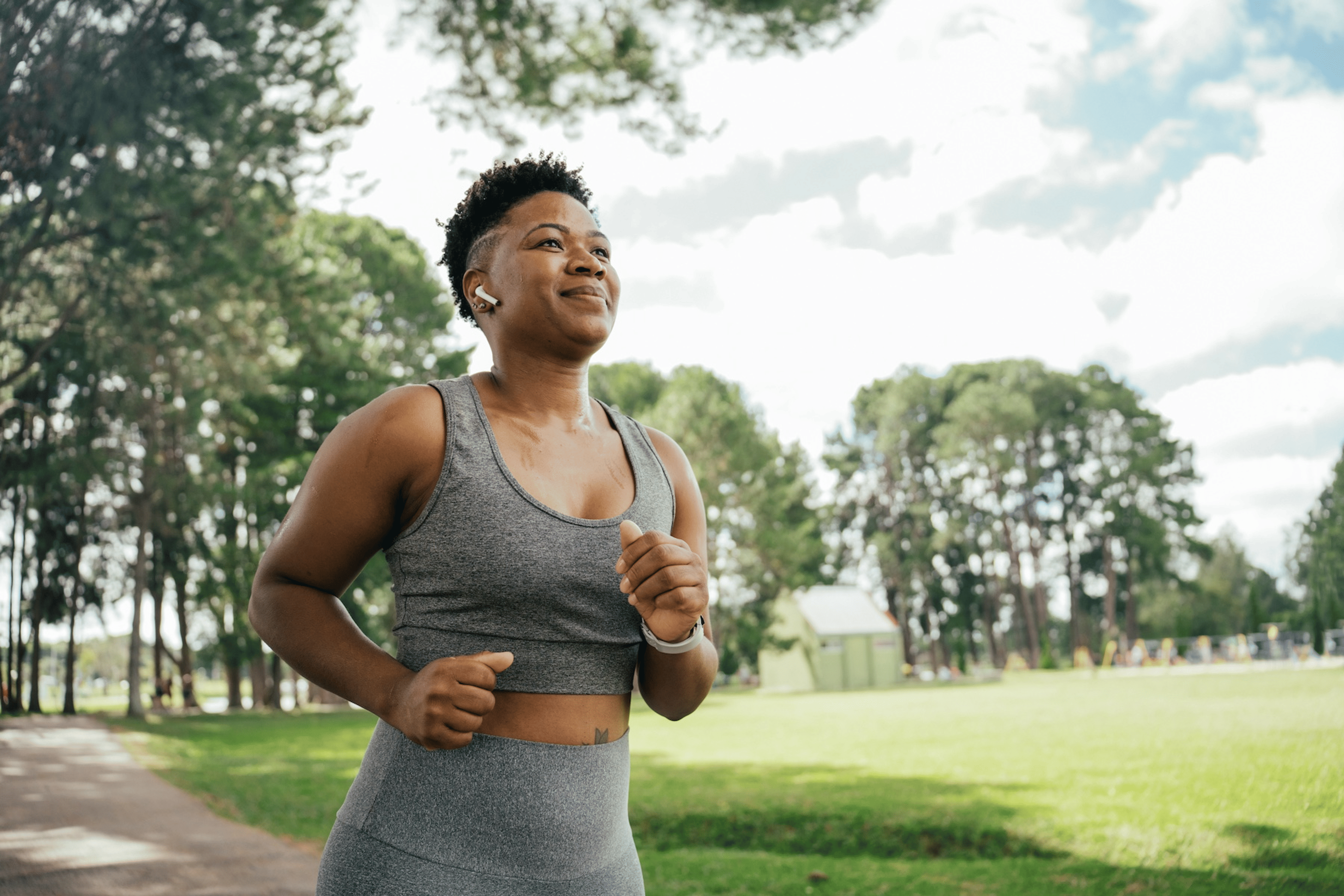 A person running on a sunny warm day in a park.