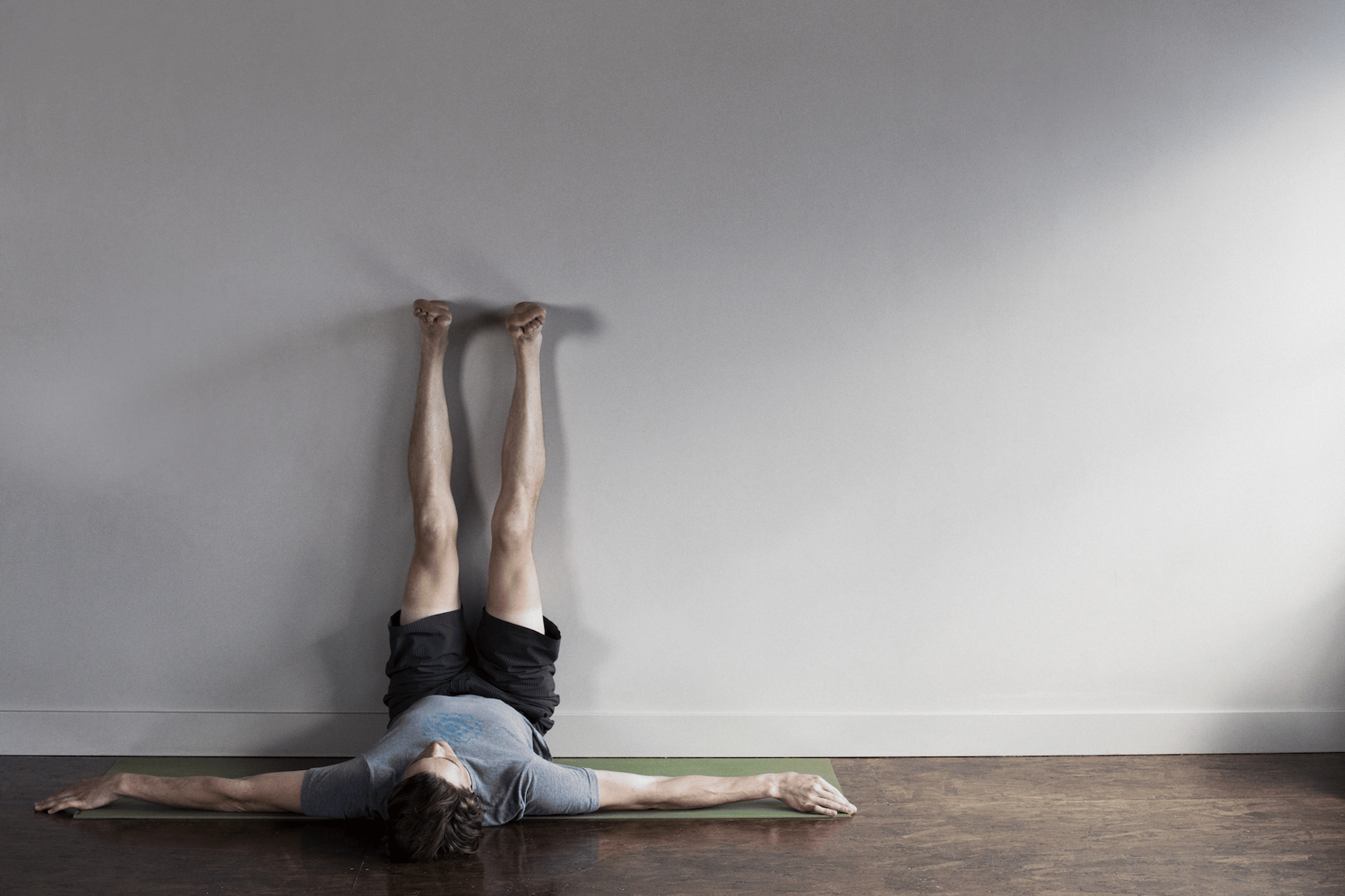 Man does Legs Up the Wall Pose, a yoga inversion