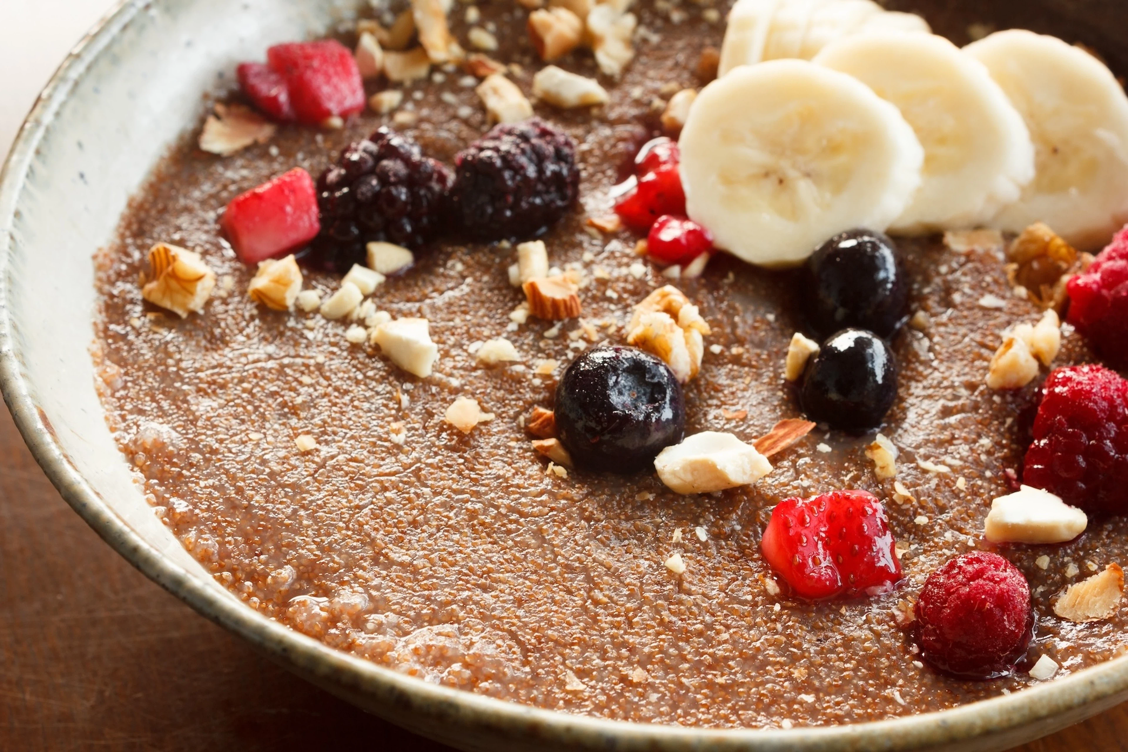 Porridge made with teff (a non-meat protein source) and topped with nuts and berries and banana slices.