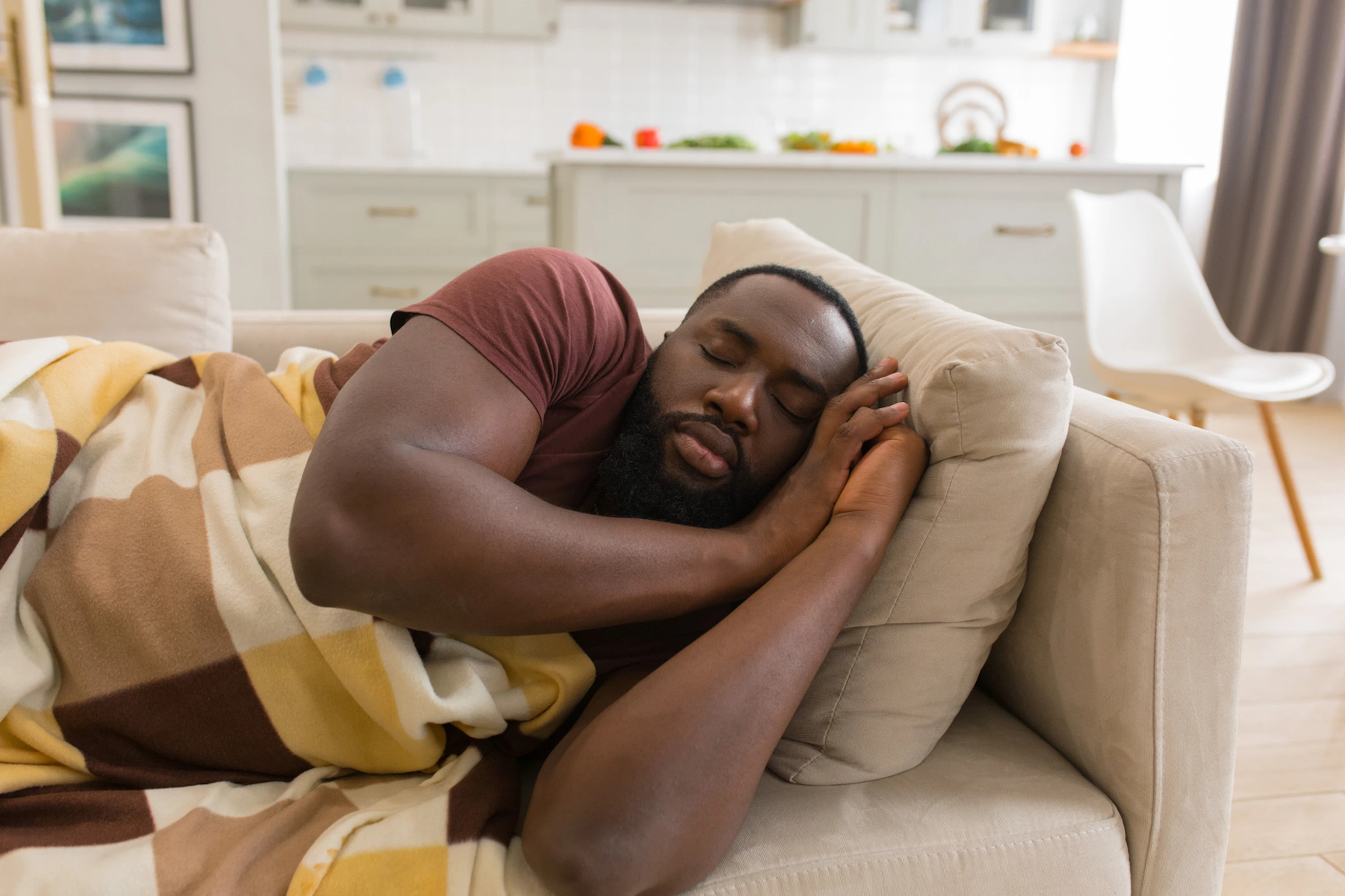 A man taking a power nap on a couch.