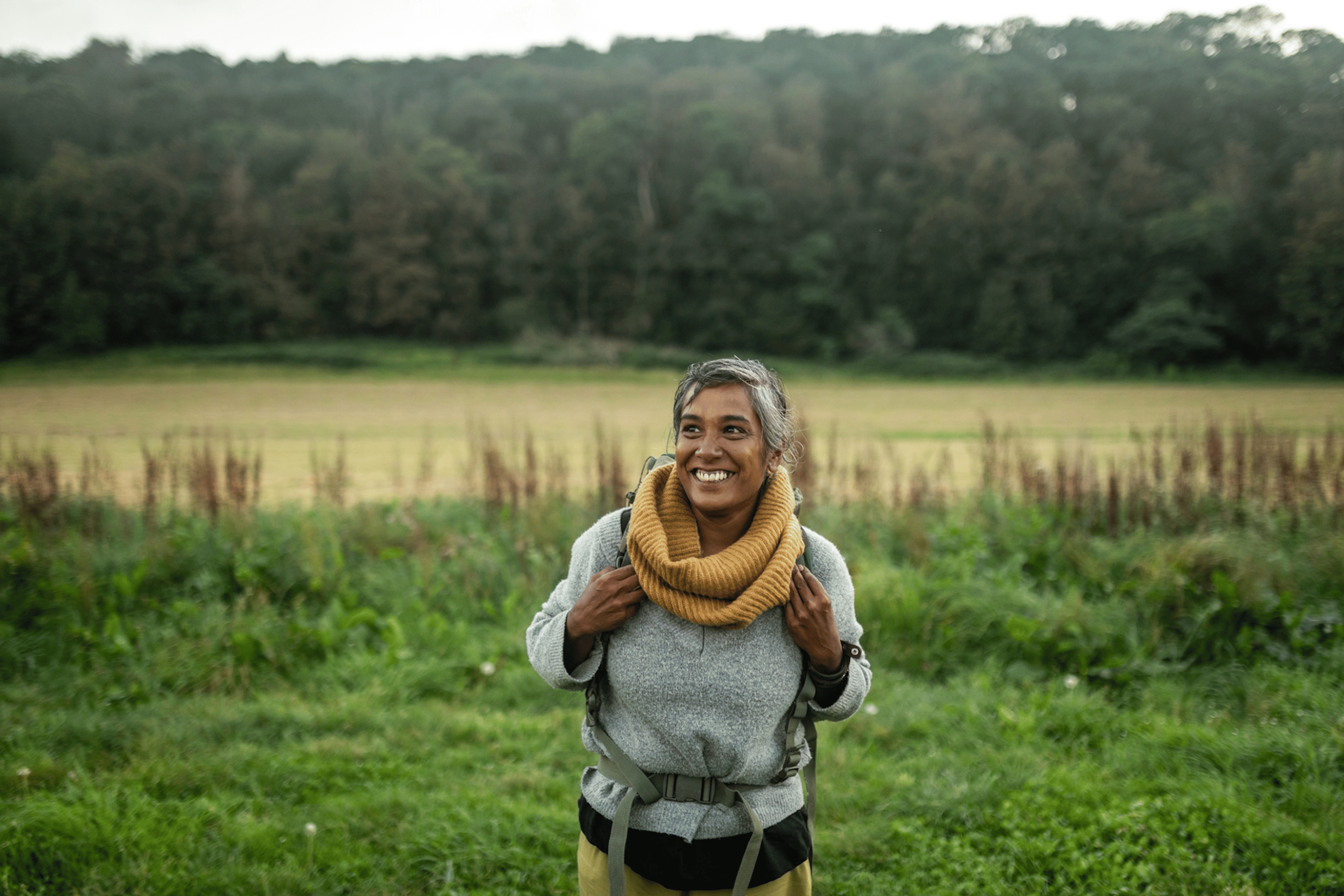Woman rucking outside through a grassy area