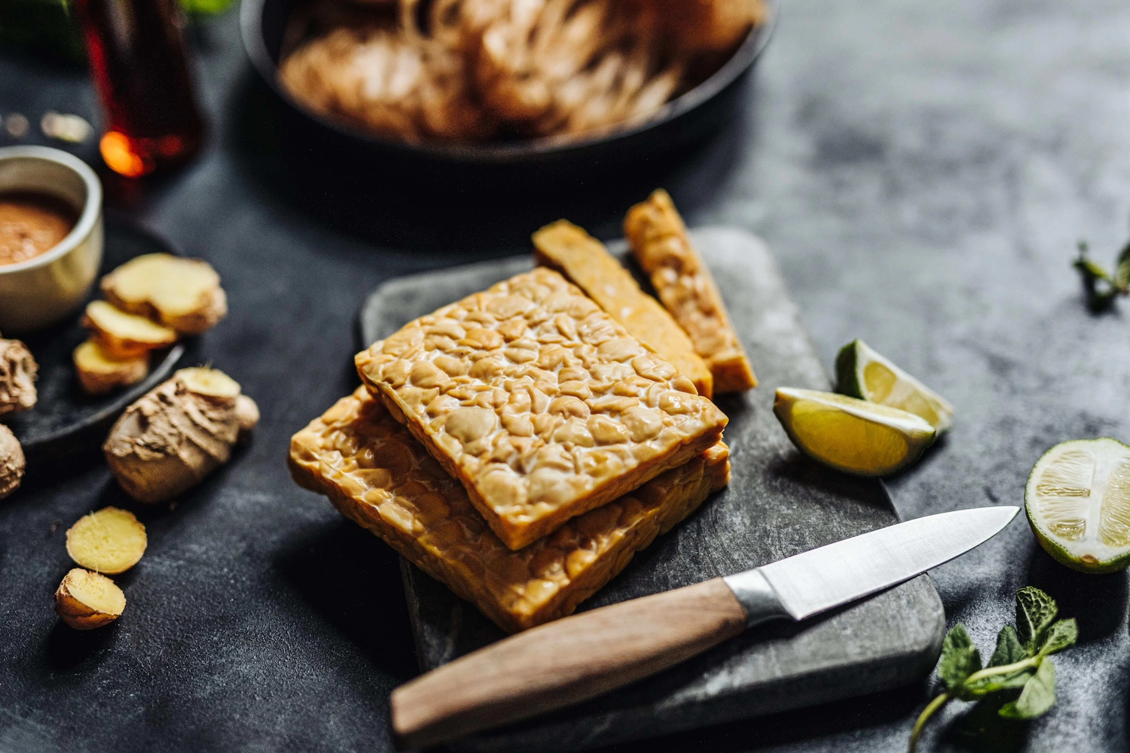 Tempeh squares on a cutting board.