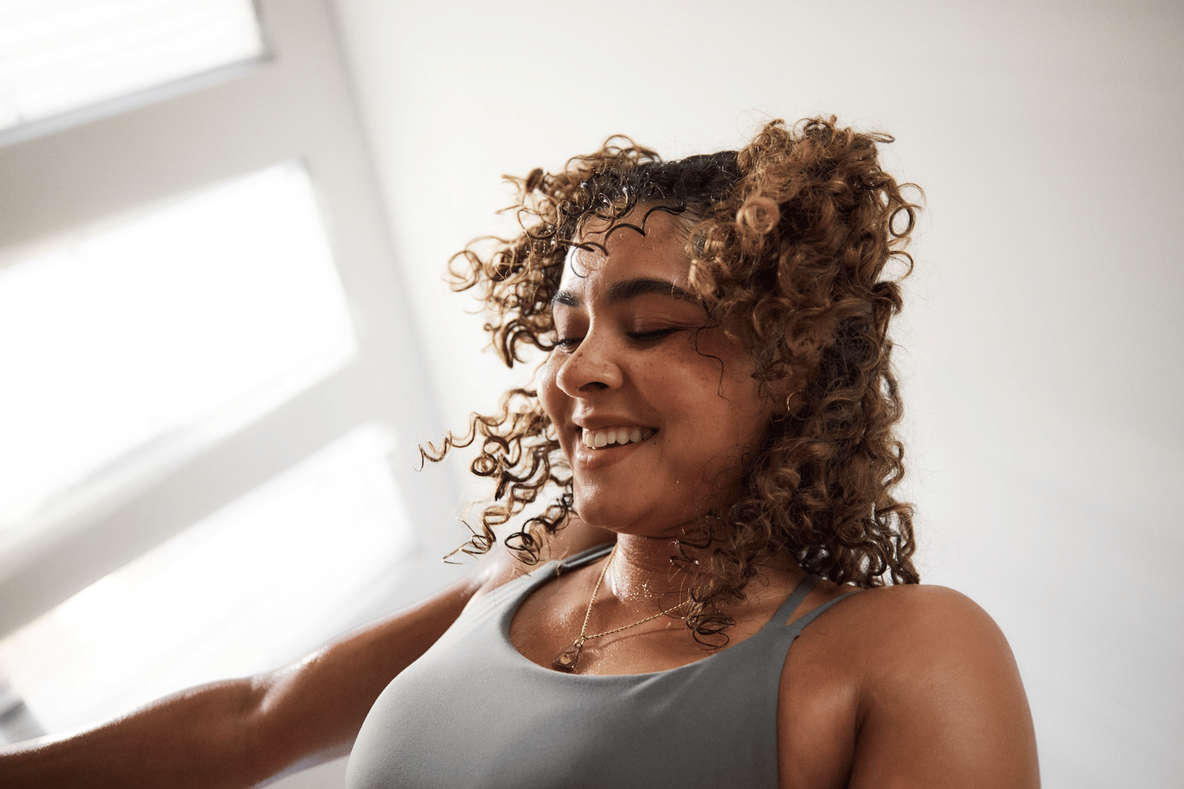 A close-up photo of a happy woman feeling confident during a workout. 